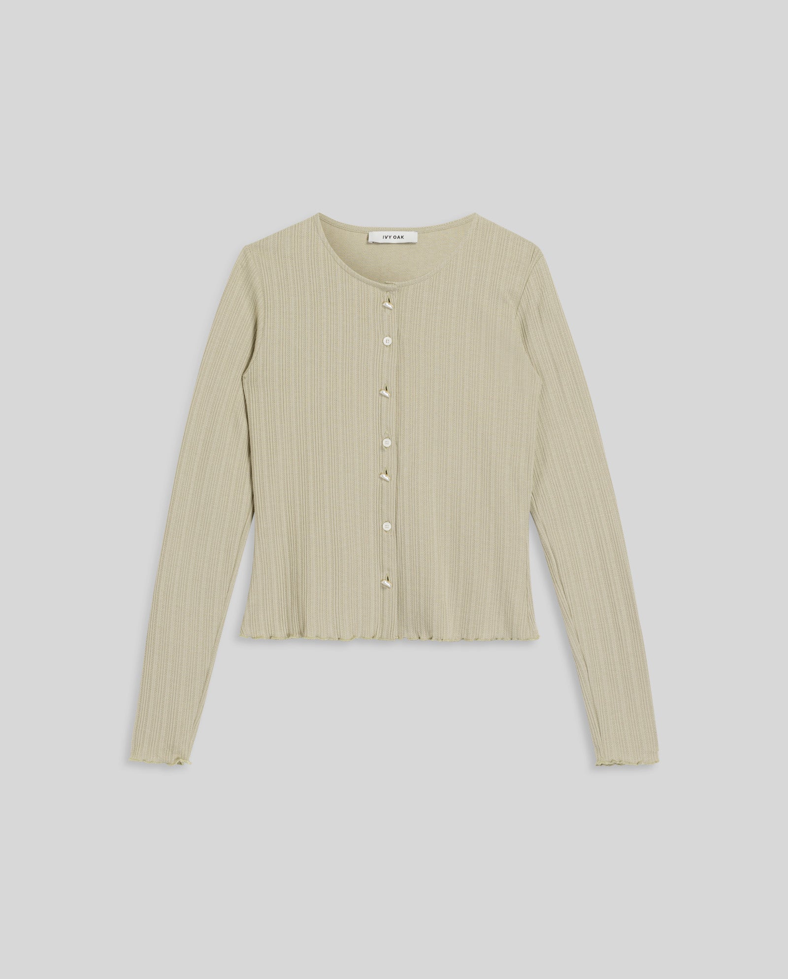 The IVY OAK KAMILLE Cardigan is a light beige, classic fit piece with a ribbed texture, front buttons, and long sleeves, shown laid flat on a white background.
