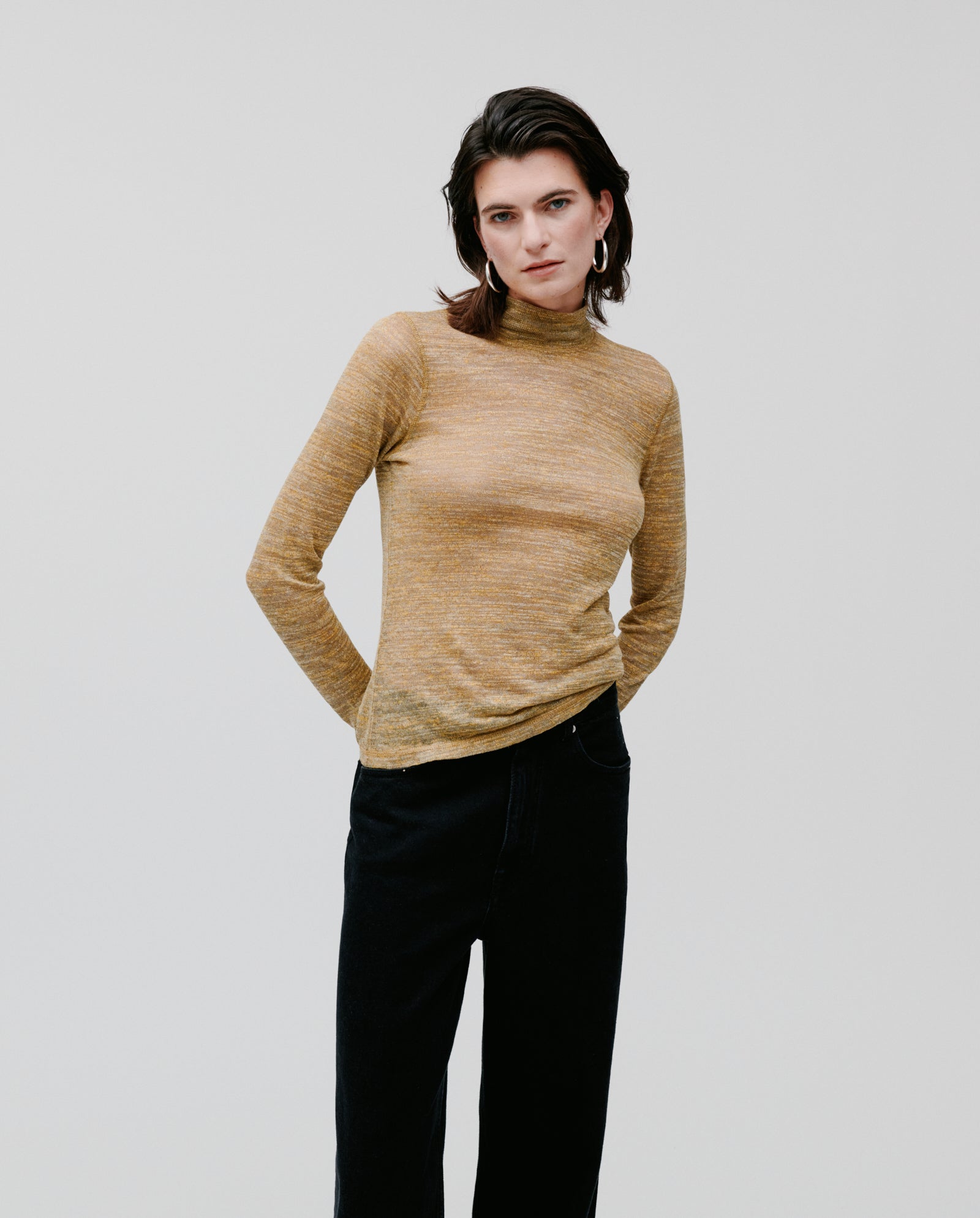 Person wearing the FELINE Top by IVY OAK in mustard yellow linen blend with black pants, standing against a plain white background.