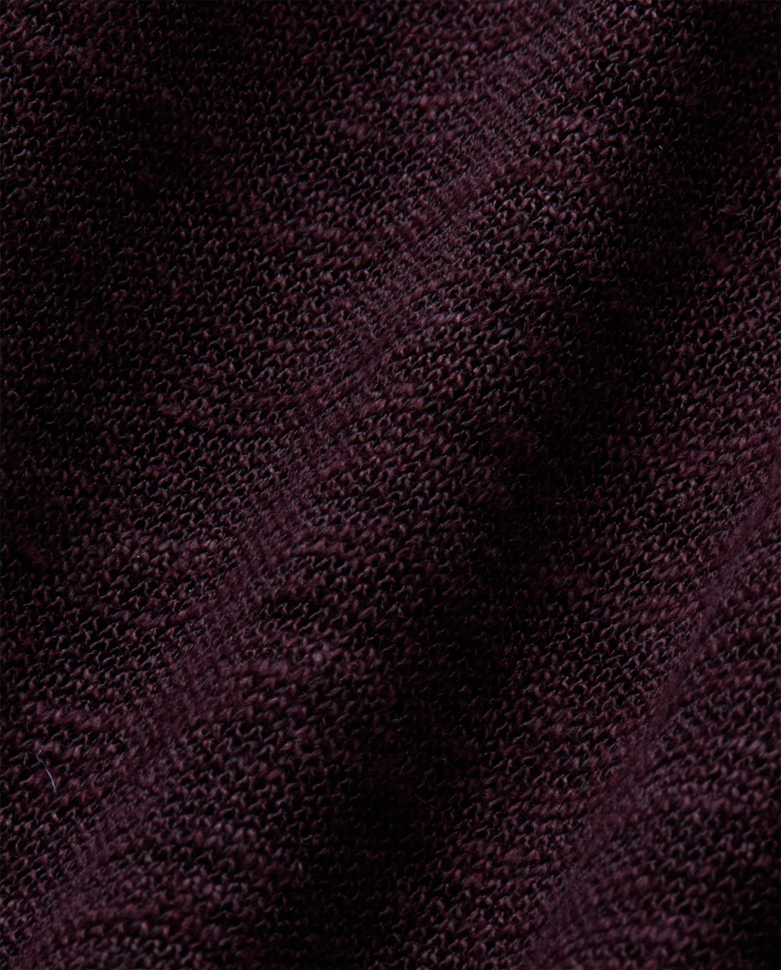 Close-up of dark maroon knitted fabric with a diagonal seam and textured pattern, perfect for the FELINE Top by IVY OAK.