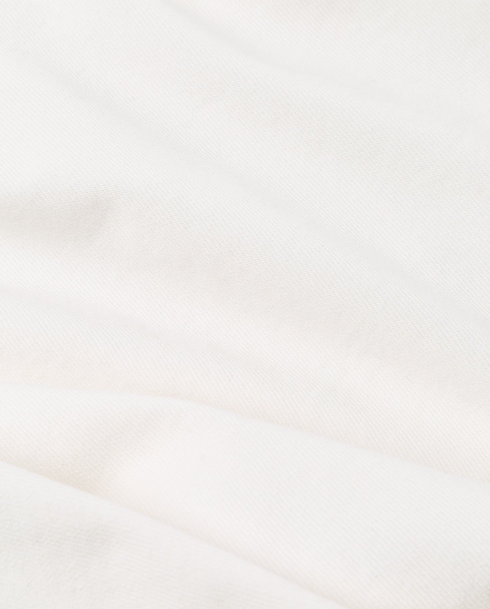 Close-up of the soft, white fabric from the IVY OAK ELMA Blouse, featuring gentle folds and a subtle textured pattern—ideal for adding chic elegance to your wardrobe.
