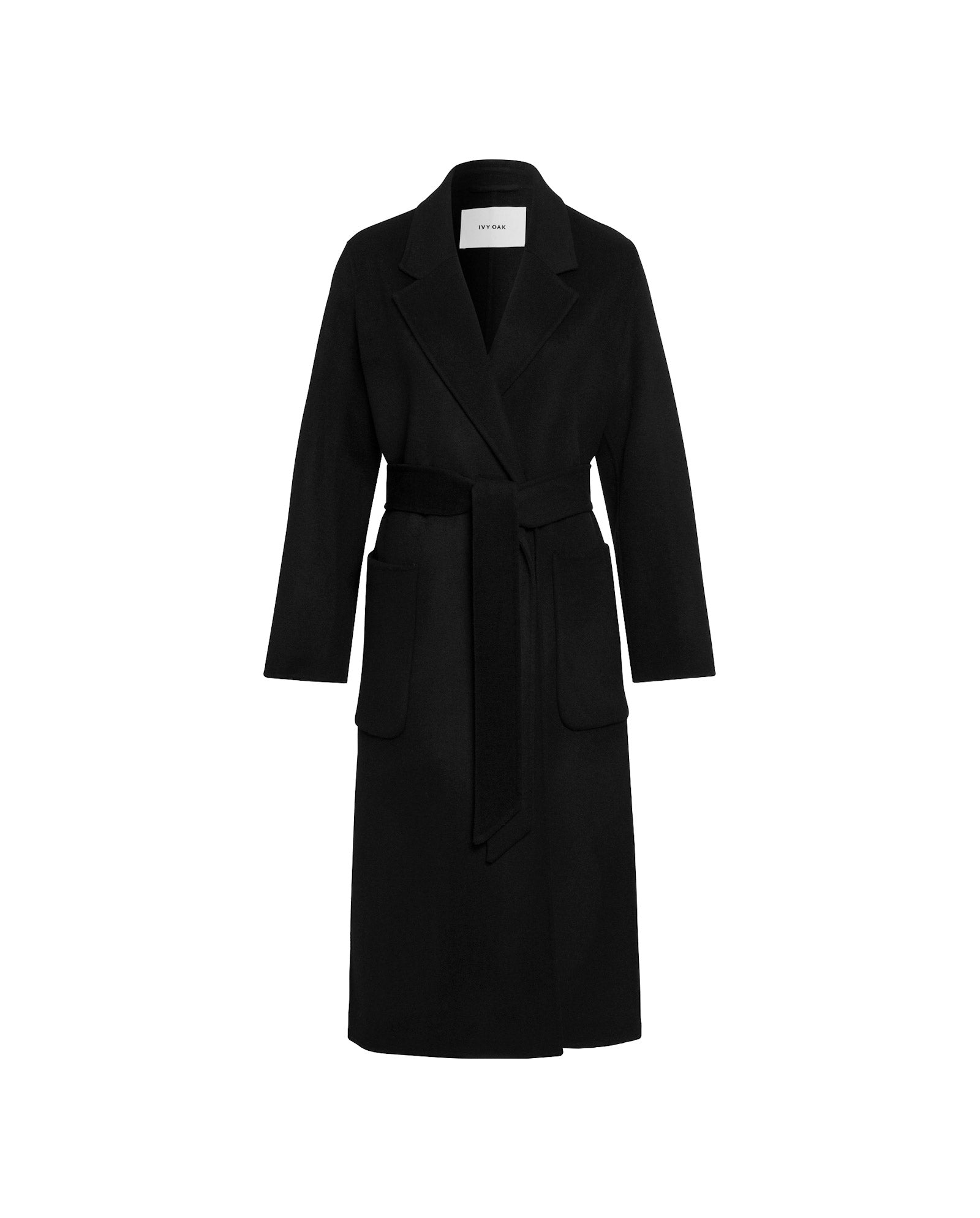 The CELIA Doubleface Coat by IVY OAK is a long black midi wool coat with notched lapels, two large front pockets, and a belted waist. Made from Responsible Wool Standard certified materials. Shown on a white background.