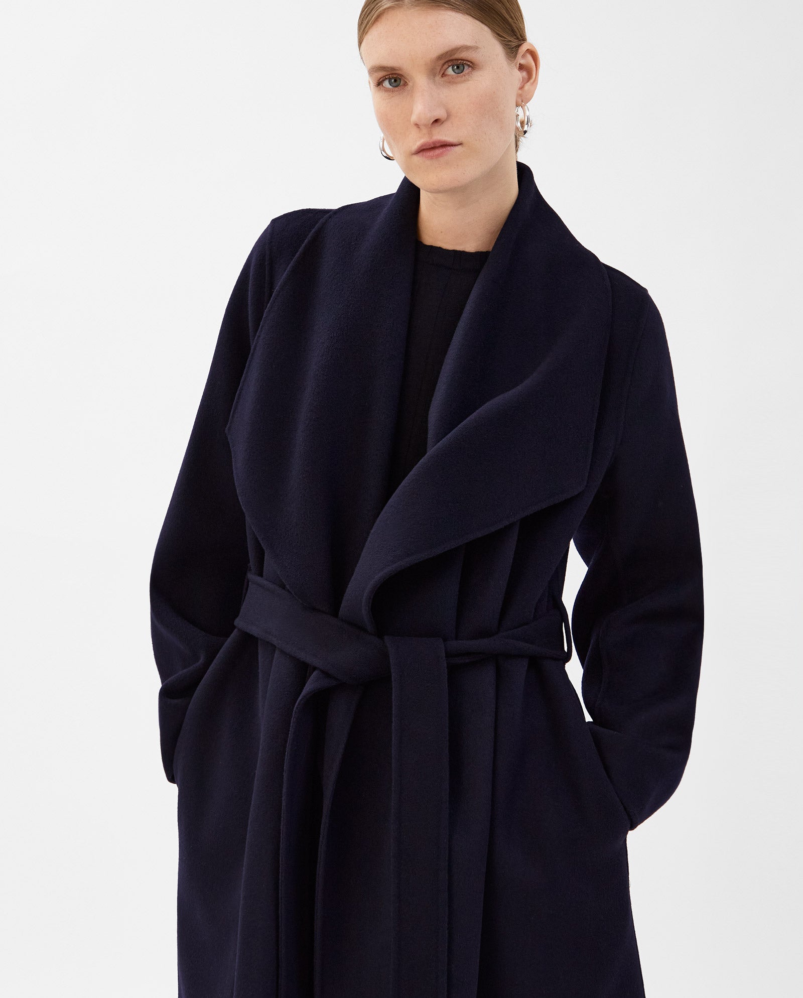 A woman wears the IVY OAK CARRIE ROSE Wool Coat, featuring a large lapel collar and crafted from Responsible Wool Standard certified fabric, standing against a plain white background.