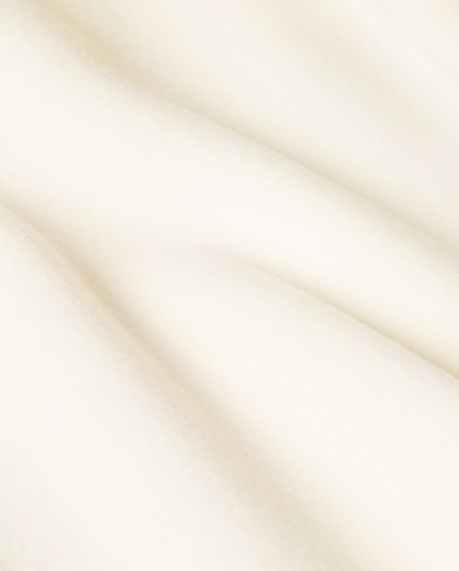 The CELIA Doubleface Wool Coat by IVY OAK features soft, cream-colored fabric with gentle folds and a smooth, velvety texture—perfect for a loose fit or stylish midi-length design.