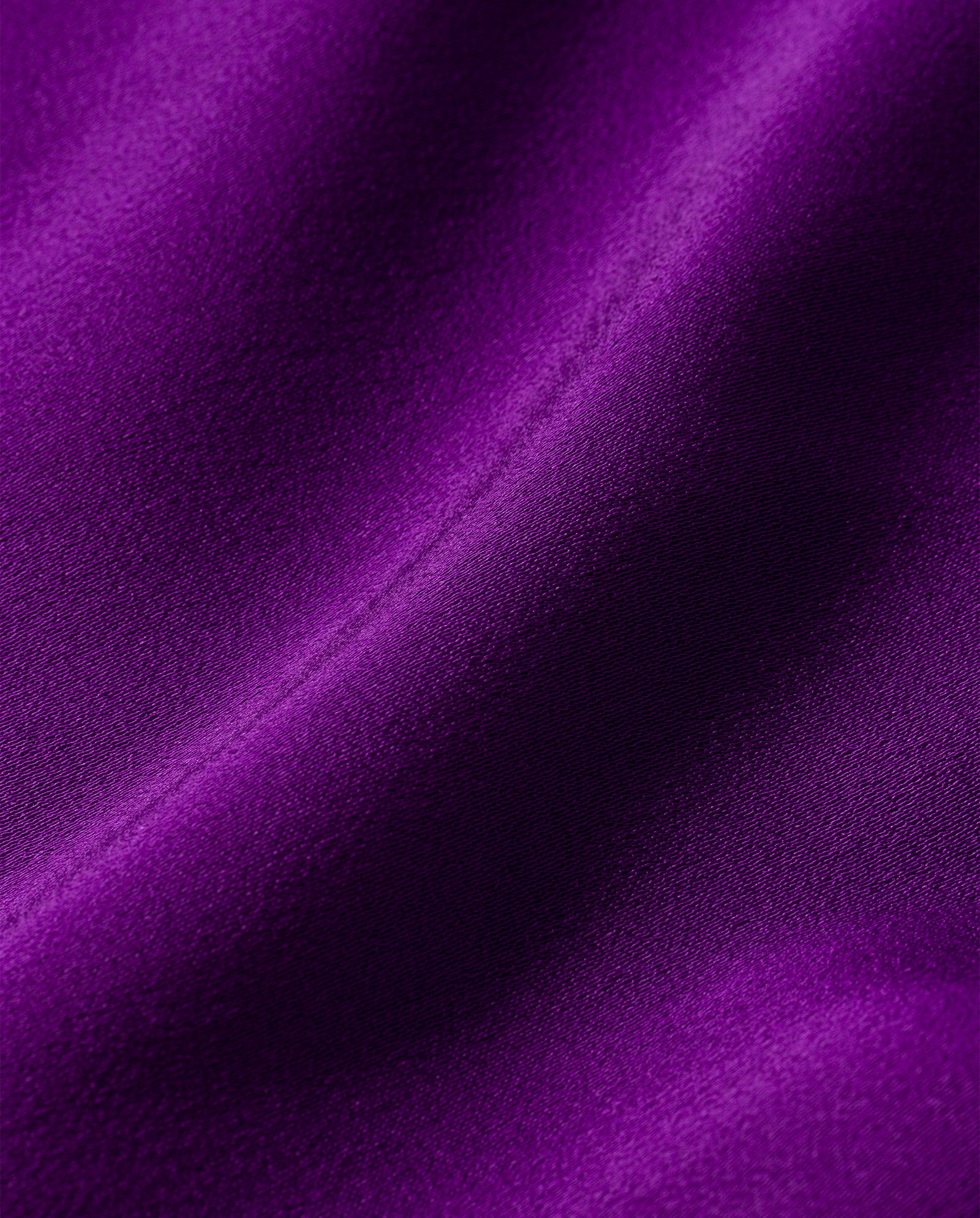 Close-up of smooth, purple fabric with soft folds and texture, perfect for the IVY OAK PHILIPPINE Jumpsuit—a satin wide-leg design.