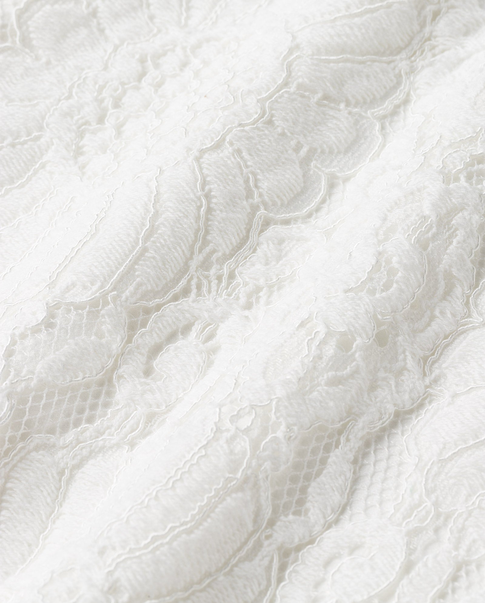 Close-up of the MAGDA Dress by IVY OAK, showcasing its delicate lace fabric with textured details and intricate floral patterns—ideal for a bridal dress.