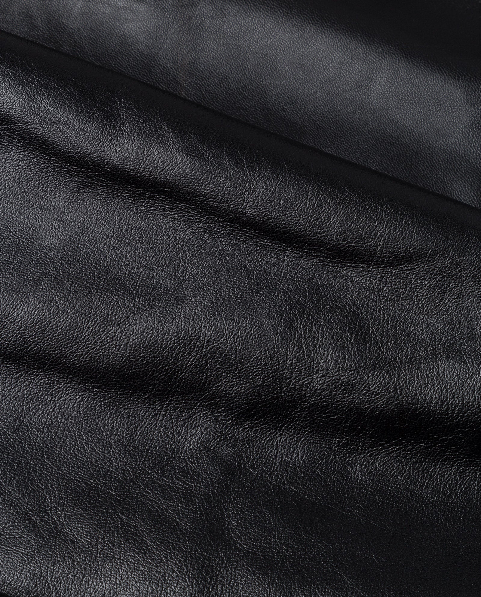 Close-up of black leather fabric from the IVY OAK LAUREEN Skirt, showing visible texture and subtle creases—perfect for adding flair to this chic midi design.