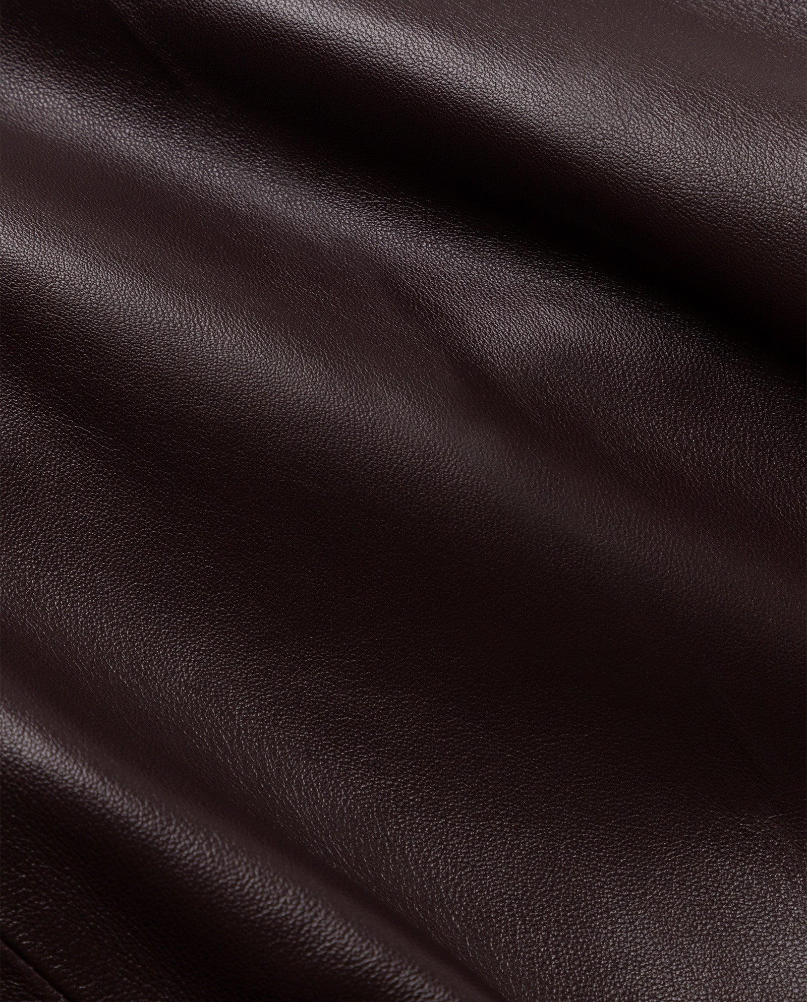 Close-up of the LILITH Trench by IVY OAK, showcasing smooth dark brown leather with subtle texture and gentle folds for a timeless look.