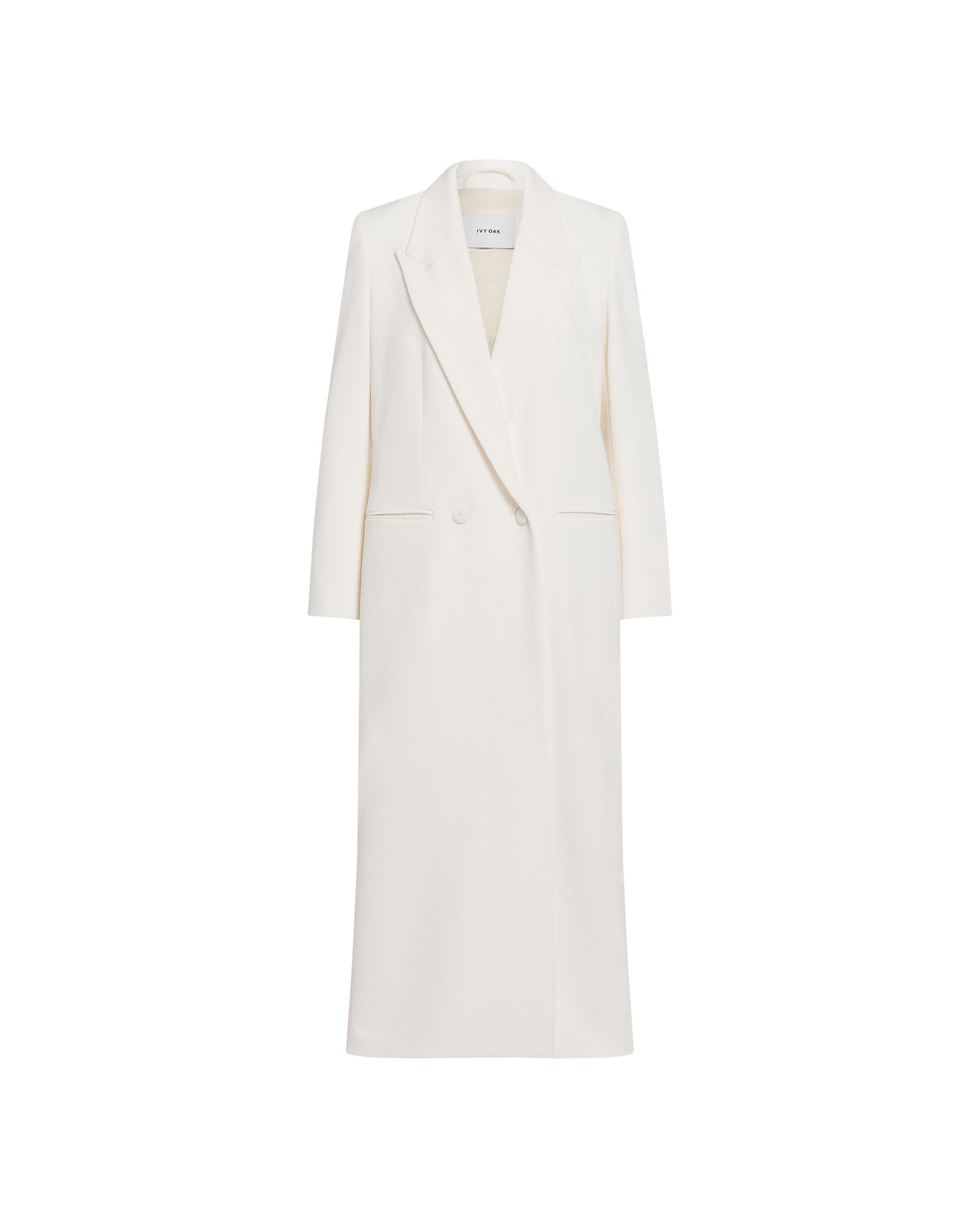 The JIL ANN Coat by IVY OAK is a long white tailored blazer featuring notch lapels, two buttons, and a minimalist matte finish, displayed on a plain background.