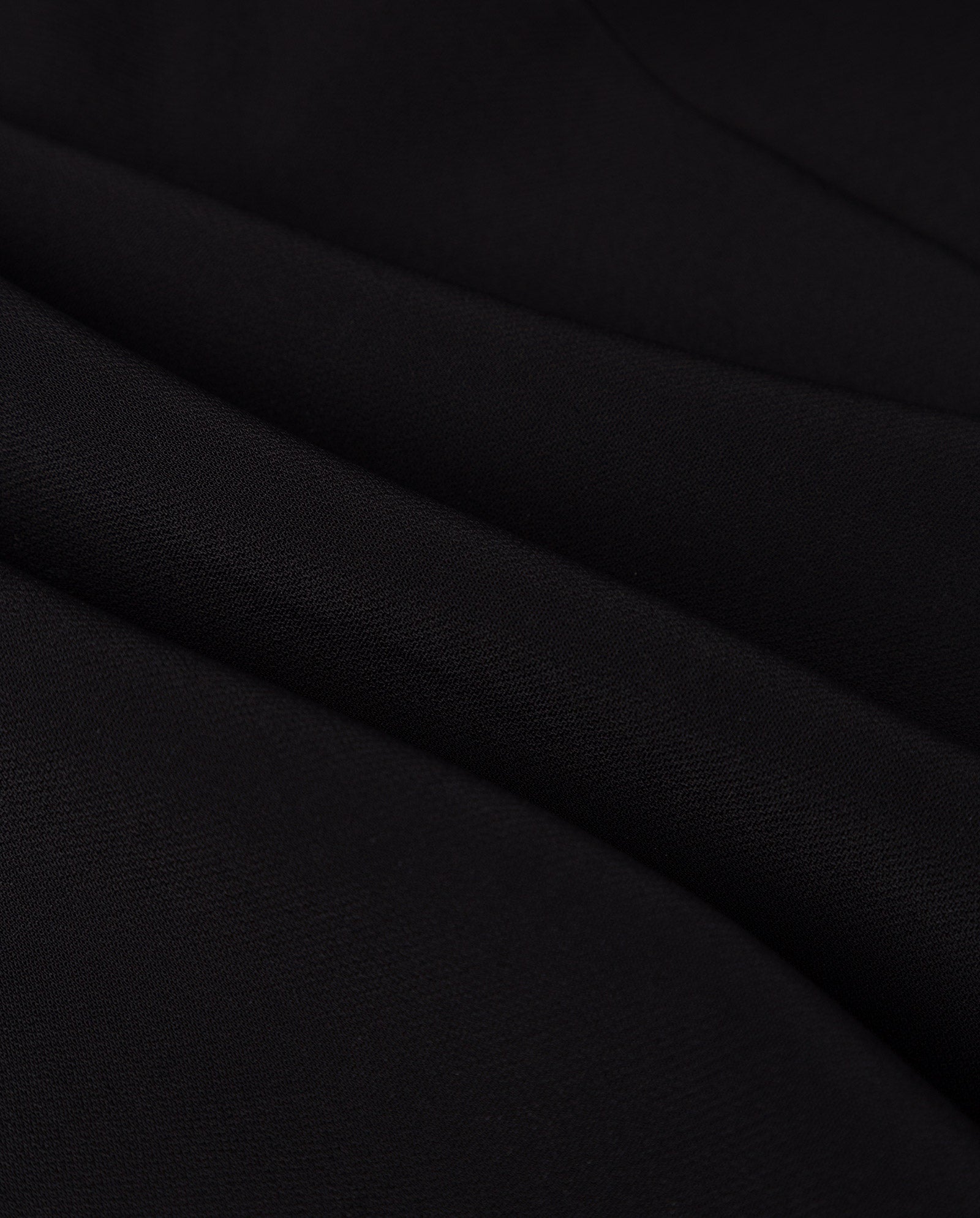 Close-up of the JANIKA Dress by IVY OAK, featuring black Viskose Mix fabric with soft folds and a slightly textured surface.