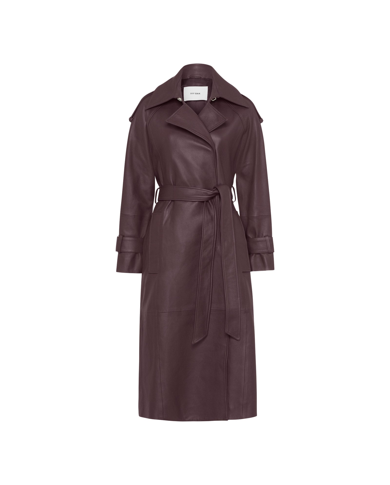The IVY OAK LILITH Trench is a long, belted dark brown leather coat with lapels, storm flap, and buttoned cuffs, shown against a white background.