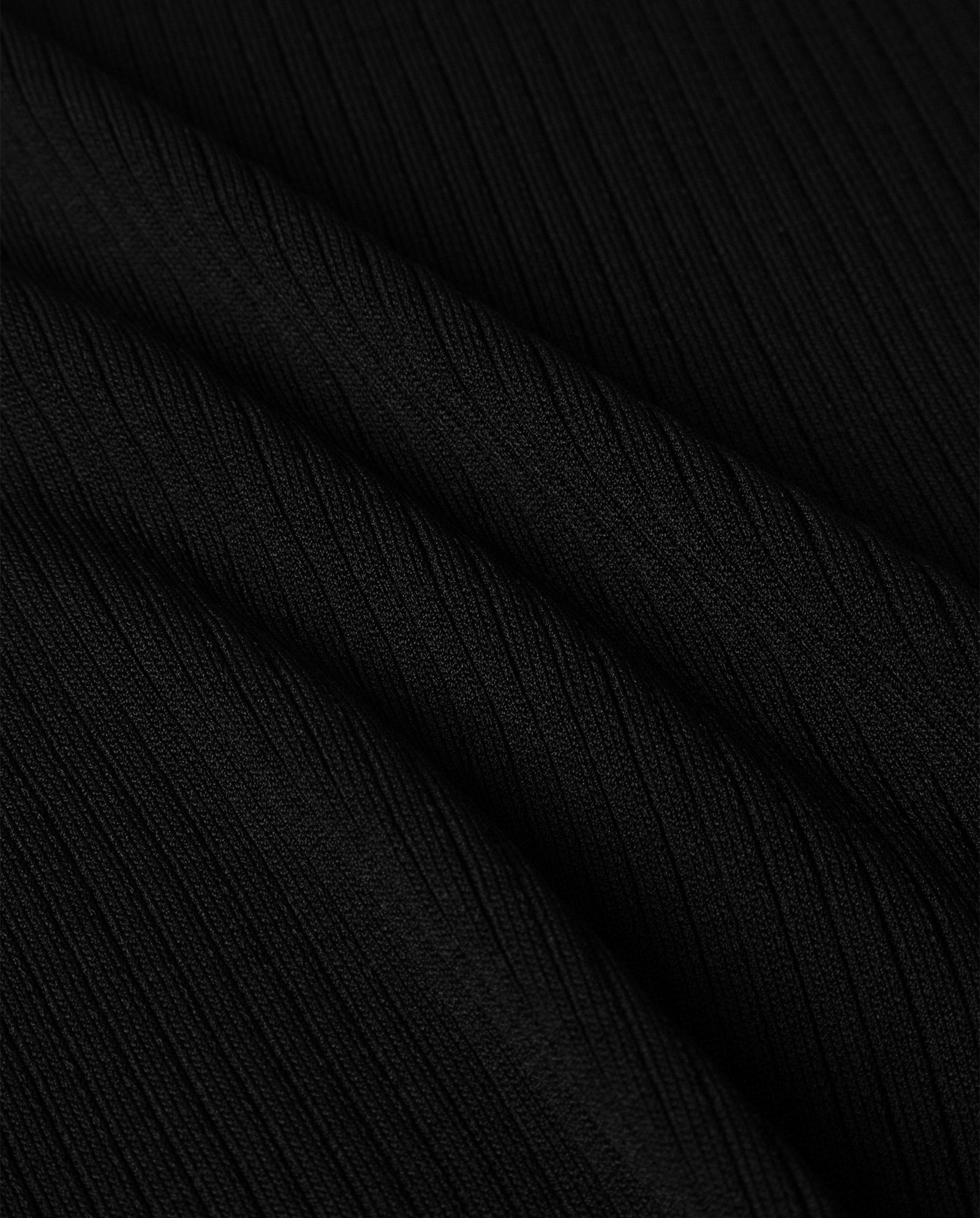 Close-up of the KESSIE Top by IVY OAK in black ribbed fabric with diagonal folds and textured vertical lines—ideal for a stand-up collar or strapless knit style.