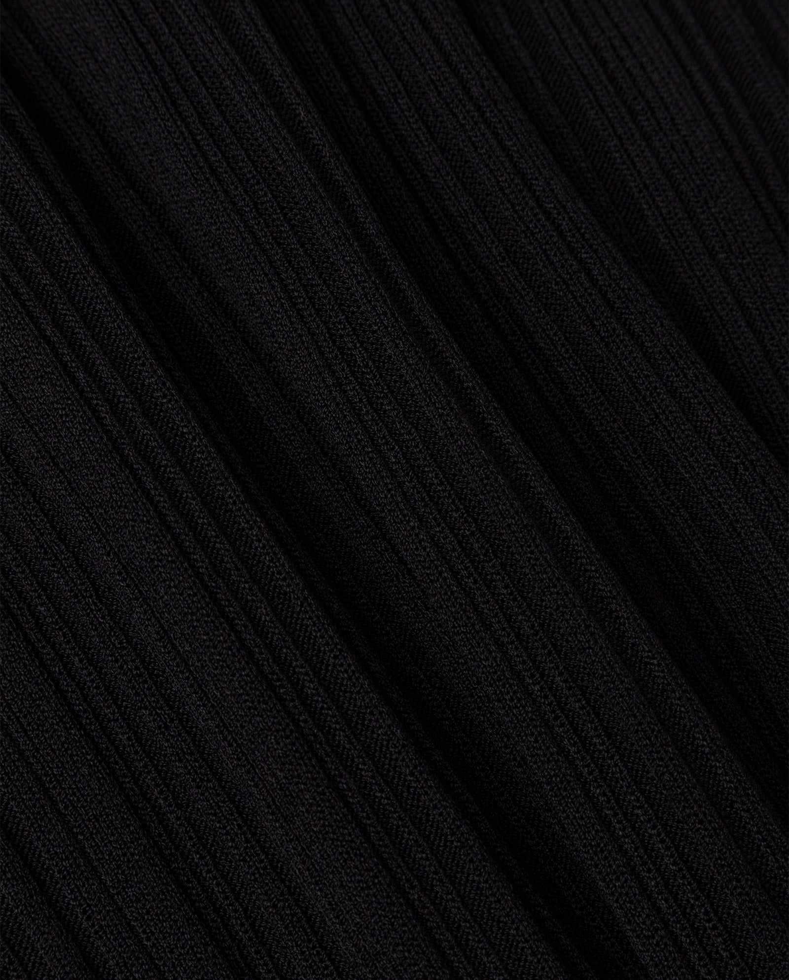 Close-up of black ribbed fabric with diagonal textured lines, highlighting the figure-hugging silhouette of the KANDICE Dress by IVY OAK.