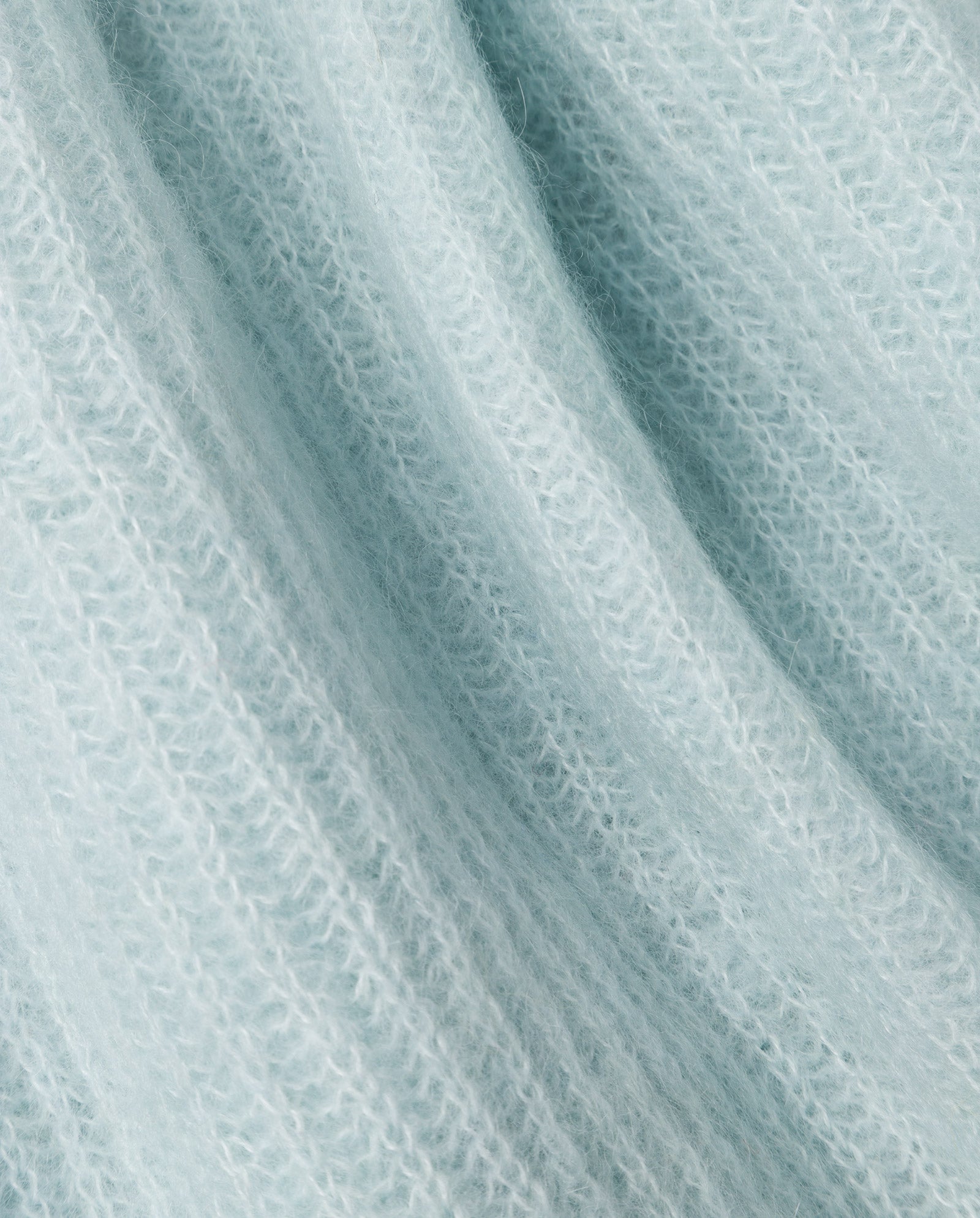 Close-up of soft, light blue alpaca blend fabric with a ribbed texture and fuzzy fibers, as featured in the IVY OAK KEONA ANN Cardigan.