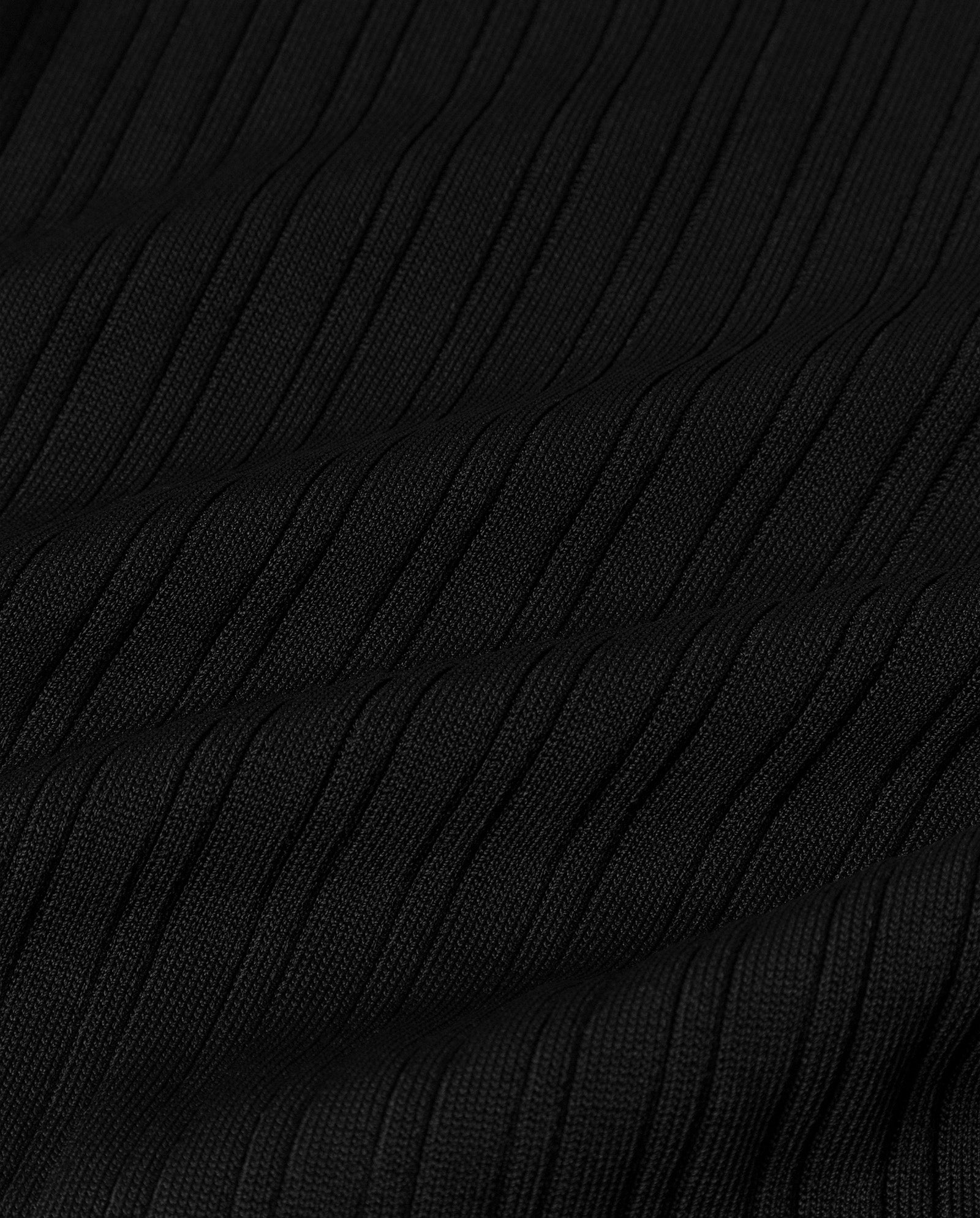 Close-up of black ribbed fabric from the IVY OAK KYLIE Jumper, showcasing a textured, wavy vertical pattern.