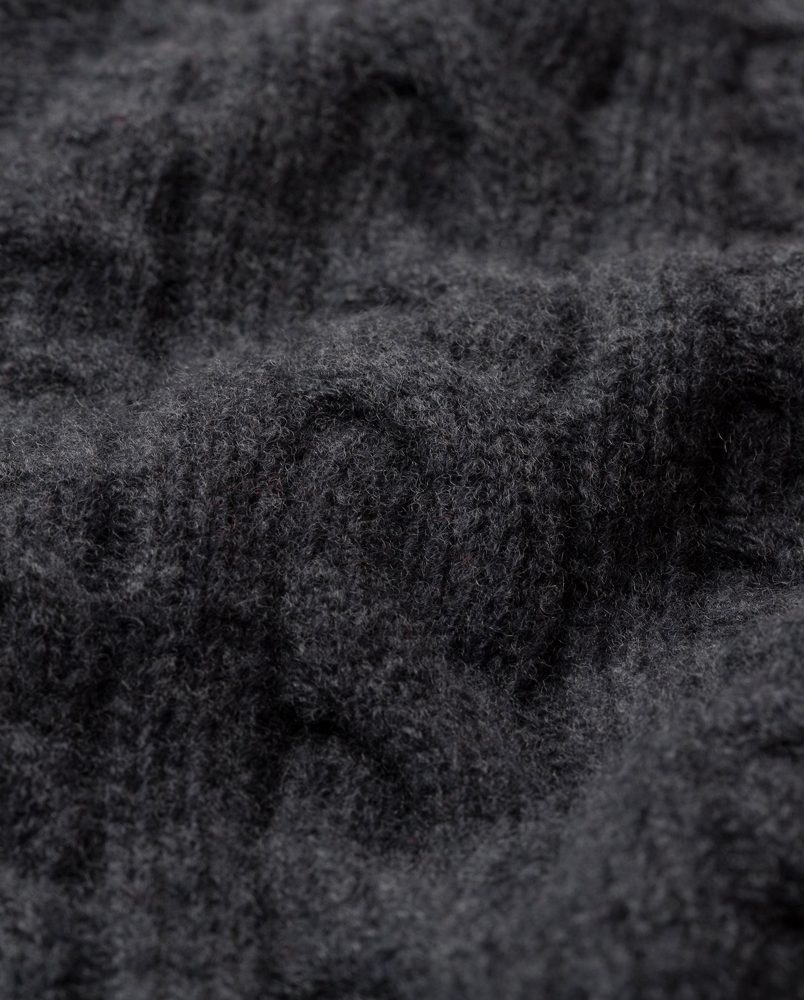 Close-up of the KYMBERLY Cardigan by IVY OAK, featuring soft, dark gray cable-knit wool with a rich textured pattern—ideal for deep v-neck styles or wide raglan sleeves.