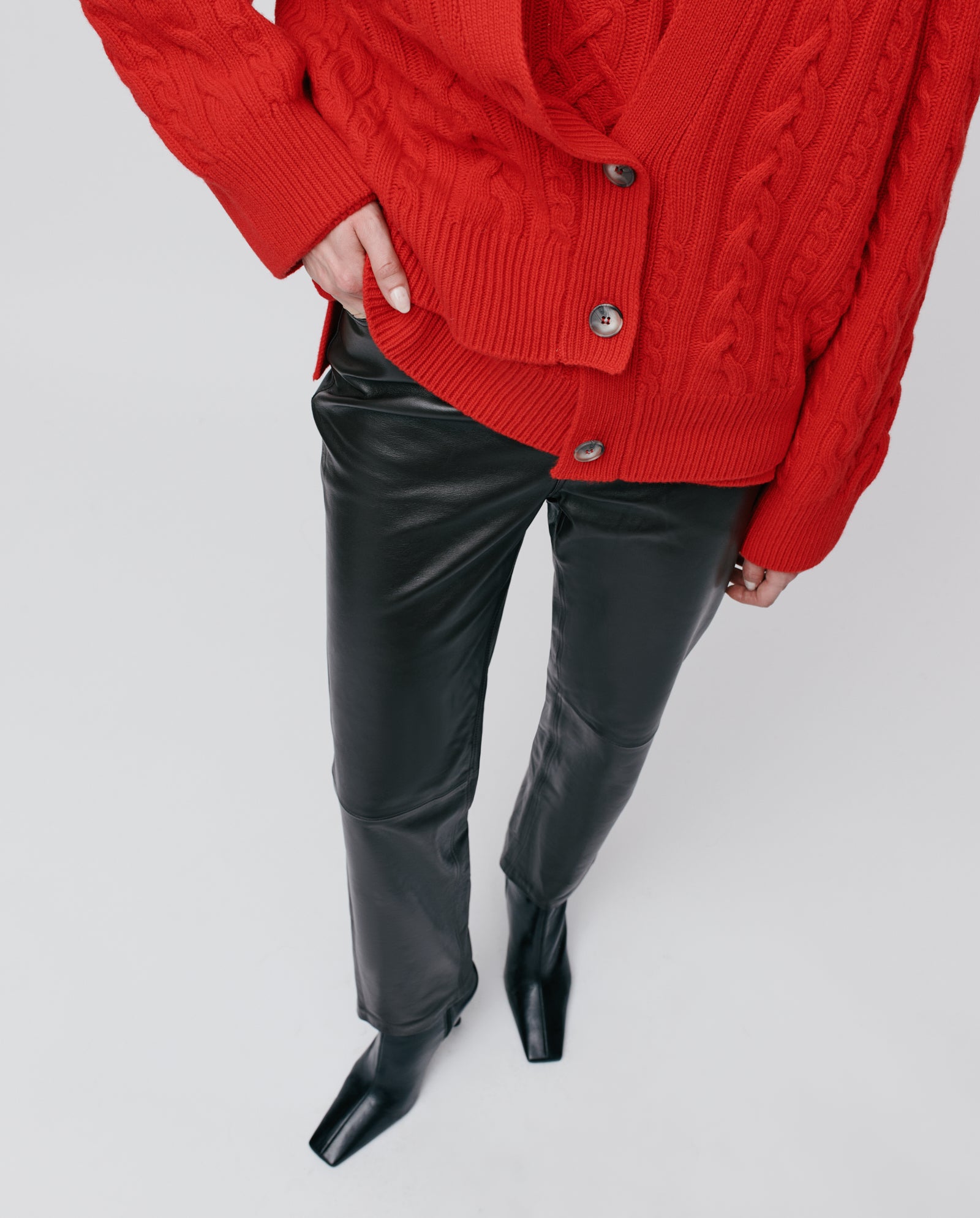 Person wearing the IVY OAK KYMBERLY Cardigan, black leather pants, and black square-toe boots, seen from above.