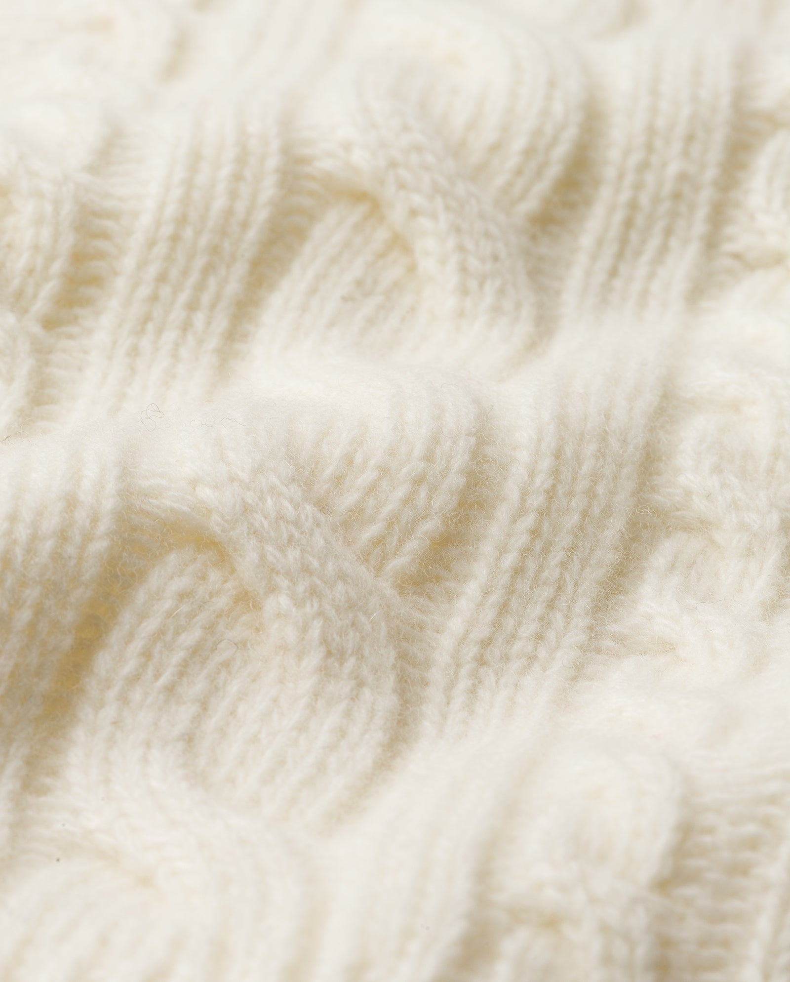 Close-up of the KYMBERLY Cardigan by IVY OAK, featuring soft, cream-colored knit with an intricate cable pattern.