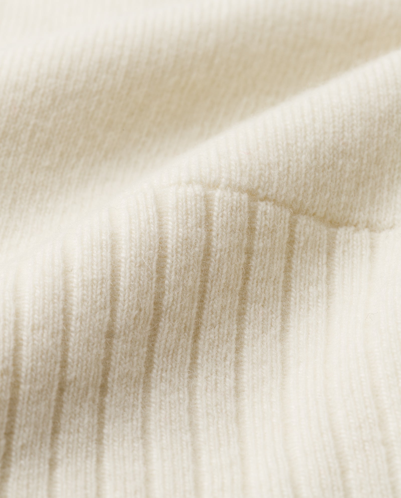 Close-up of the cream-colored, ribbed knit KAREEN ROSE Jumper by IVY OAK in soft Merino wool, highlighting its gentle texture and subtle shadows.