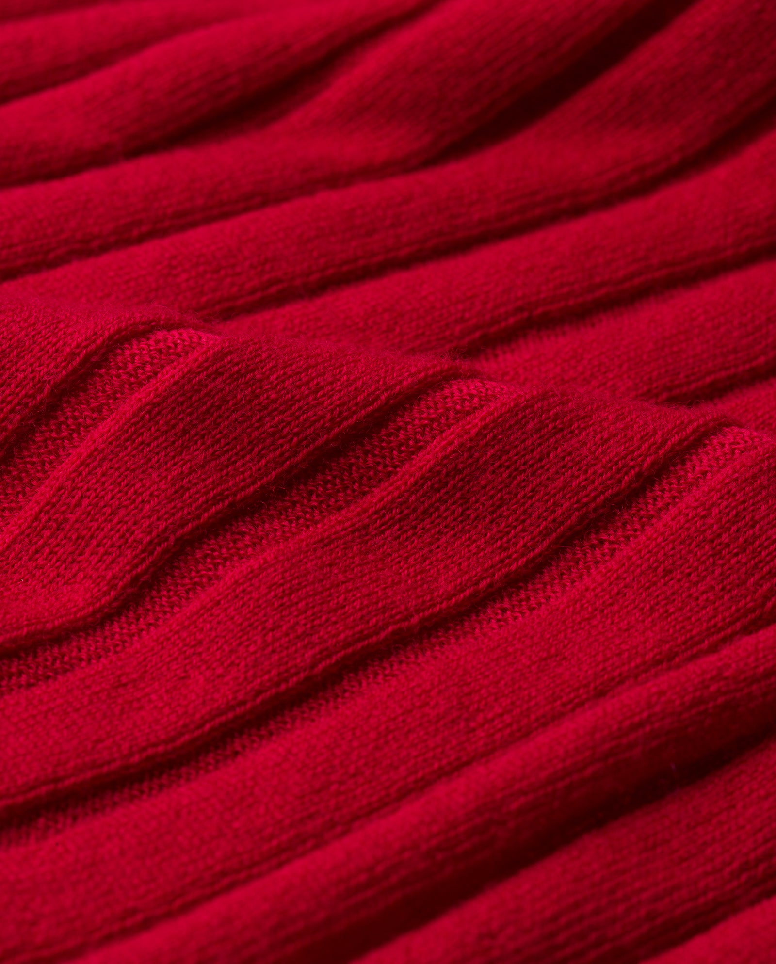 Close-up of the KACY ROSE Jumper by IVY OAK, featuring textured red knit fabric with a raised diagonal ribbed pattern typical of premium Merino wool sweaters.