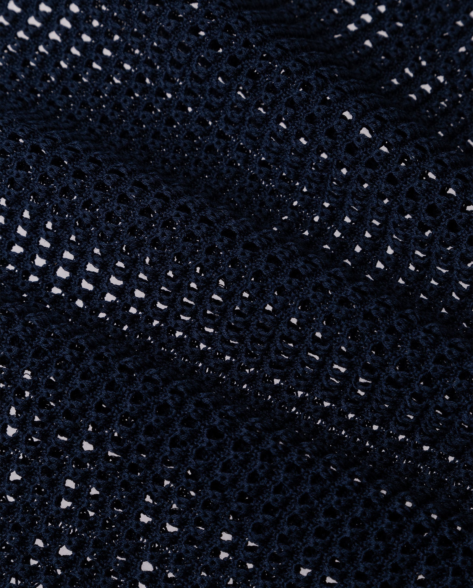 Close-up of the FLO Top by IVY OAK: dark blue, textured summer open knit mesh fabric with small holes and wavy folds—perfect for breathability.