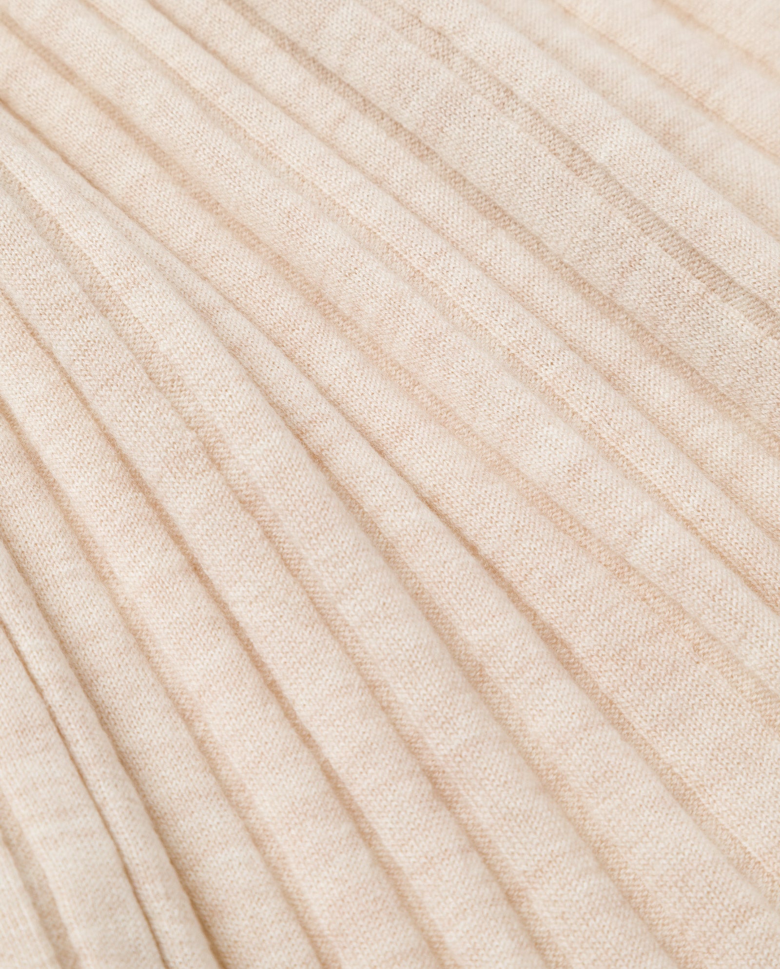 Close-up of the beige pleated fabric with vertical lines and a soft texture—perfect for the IVY OAK KACY ANN Knittop, an ideal Merino rib pullover for transitional seasons.