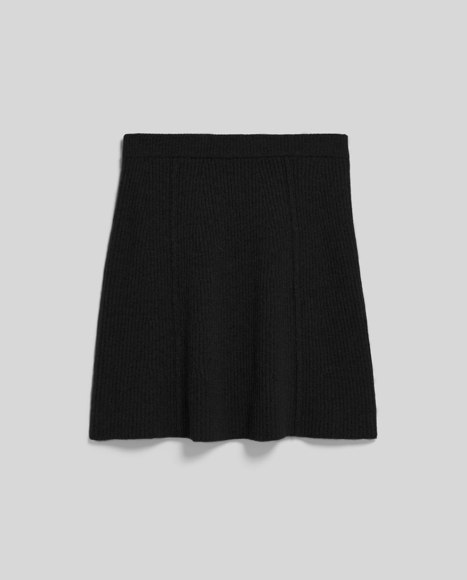 The IVY OAK KEENA Skirt is a black, ribbed-knit A-line mini with exposed seams, shown on a plain light gray background.