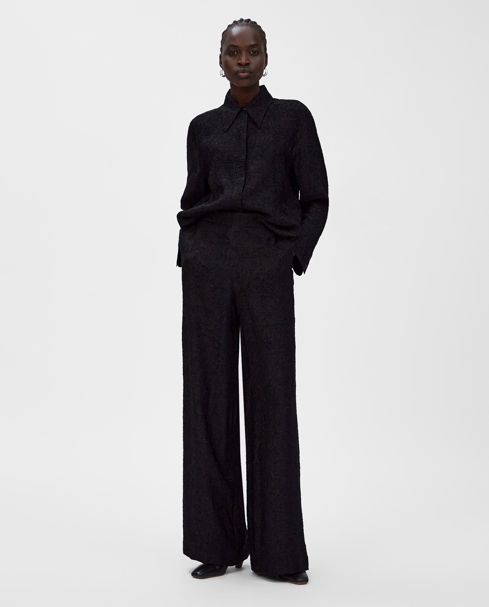 A person wearing a black textured shirt and high-waisted IVY OAK PRIYA Trouser stands against a plain white background.