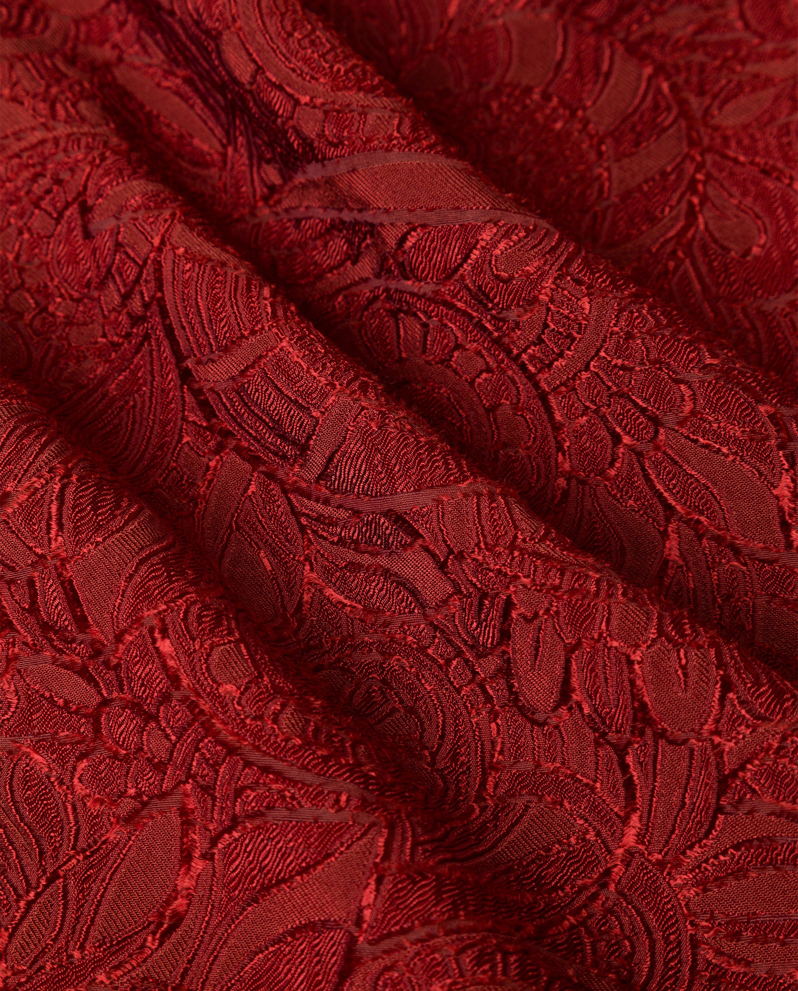 Deep red fabric with an intricate, raised floral lace pattern—ideal for crafting elegant IVY OAK PRIYA Trousers or adding a hint of fil coupé sophistication to your wardrobe.