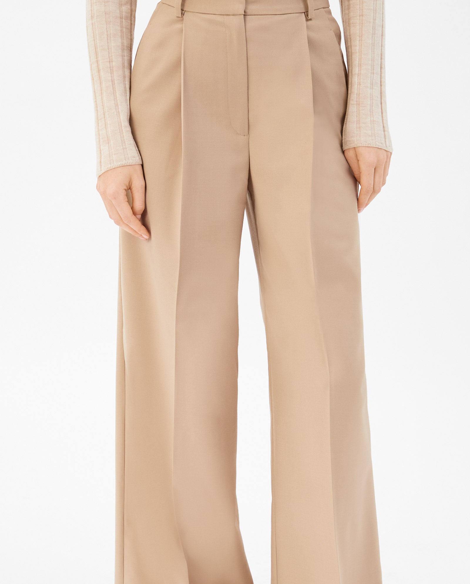 A person wearing the IVY OAK PRESCILLIA high-waisted, wide leg trousers in beige, paired with a ribbed long-sleeve top and matching blazer.