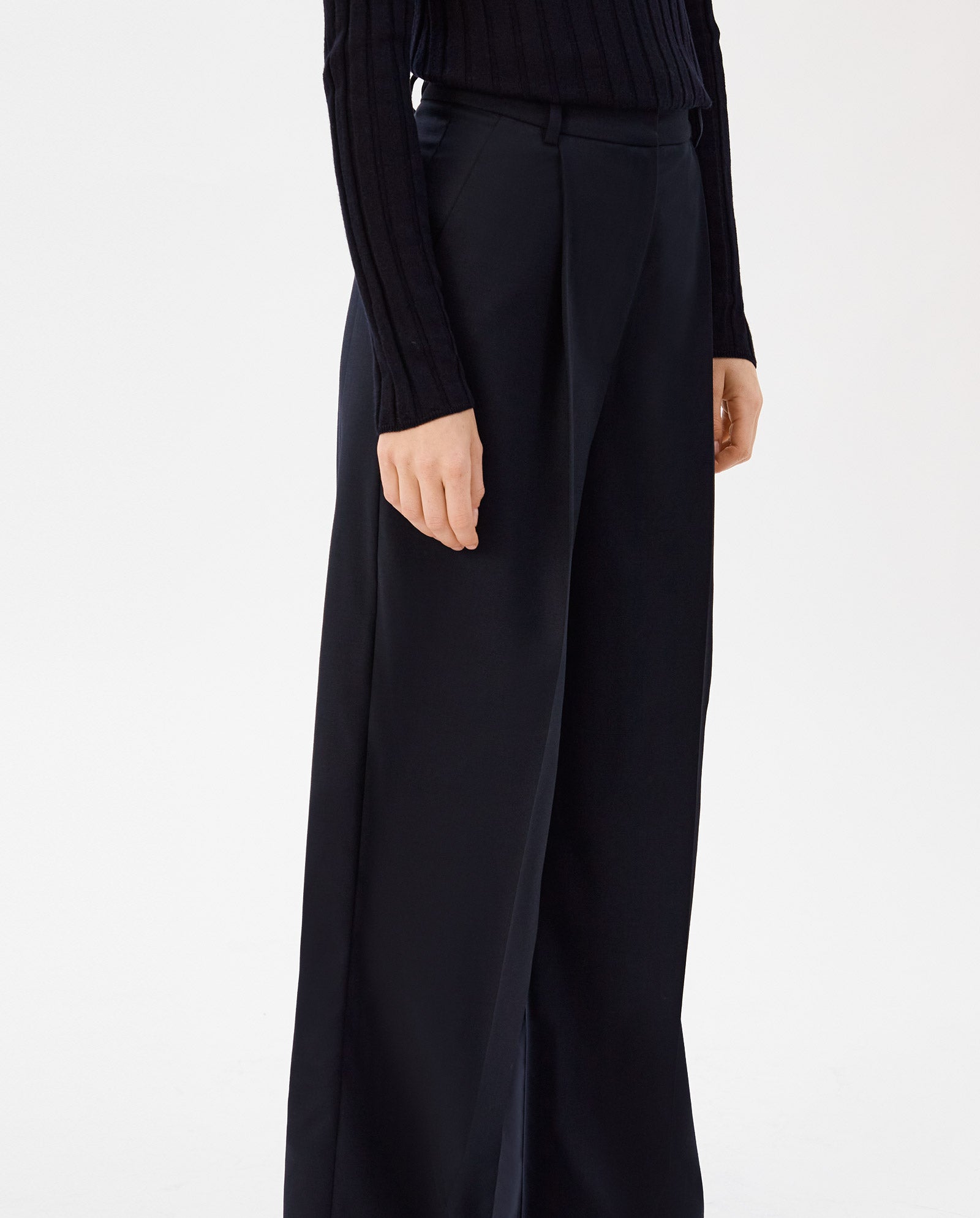 A person wearing a black ribbed sweater and wide leg PRESCILLIA Trousers by IVY OAK, shown from torso to ankles against a white background.