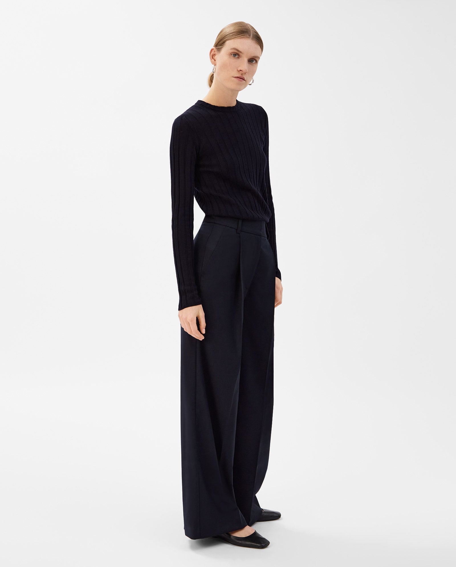 A woman in a black long-sleeve top and IVY OAK PRESCILLIA Trousers stands against a plain white background.