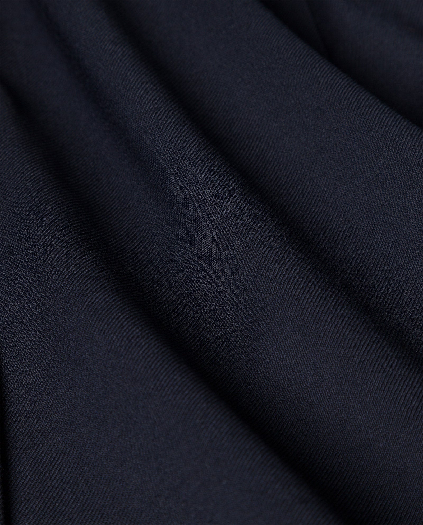 Close-up of smooth, dark navy blue fabric from the IVY OAK PRESCILLIA Trouser, showing soft folds and a subtle diagonal texture.