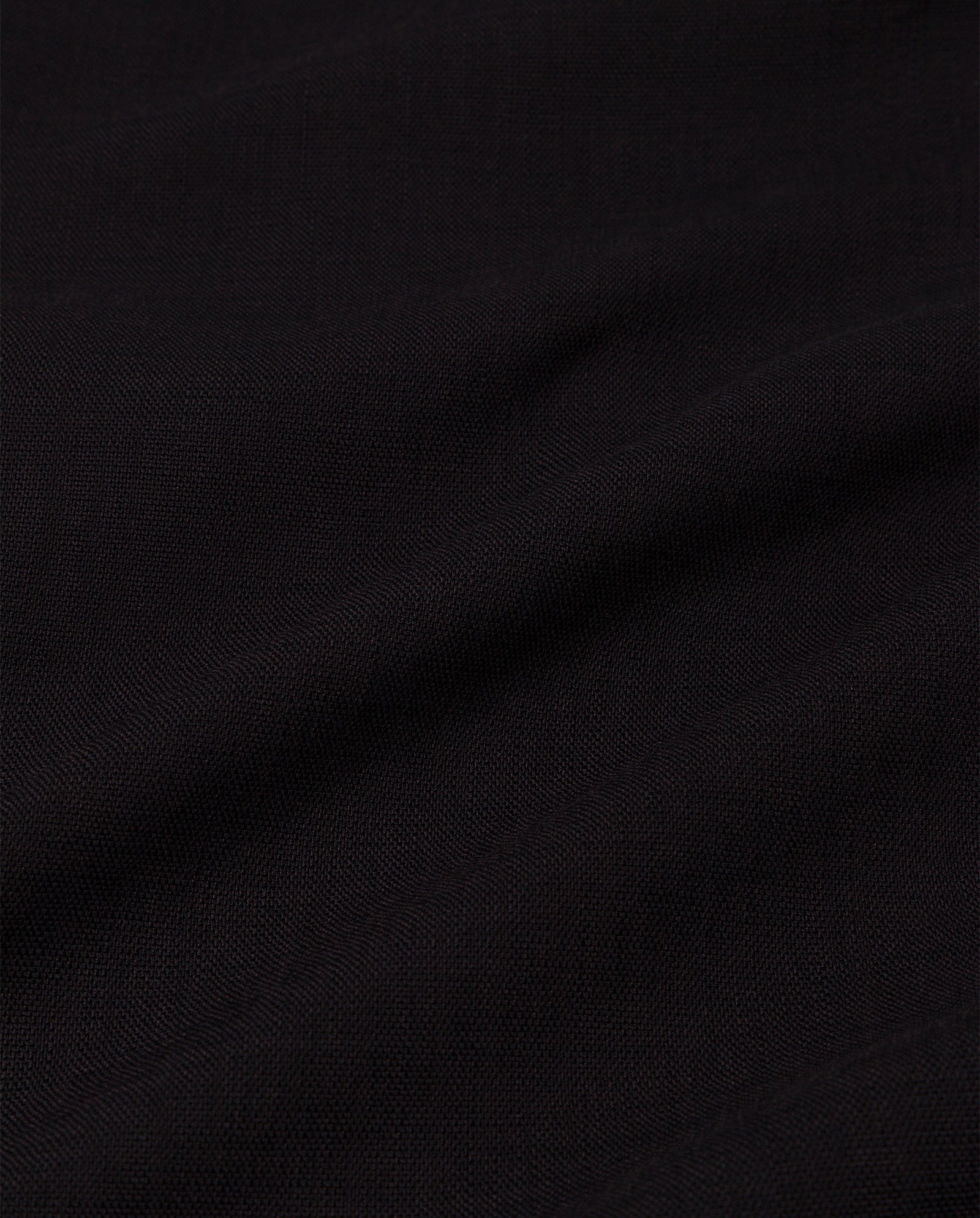 Close-up of black fabric with subtle texture and gentle folds, as seen on IVY OAKs PRESCILLIA ANN Pants—a classic style featuring refined French pockets.