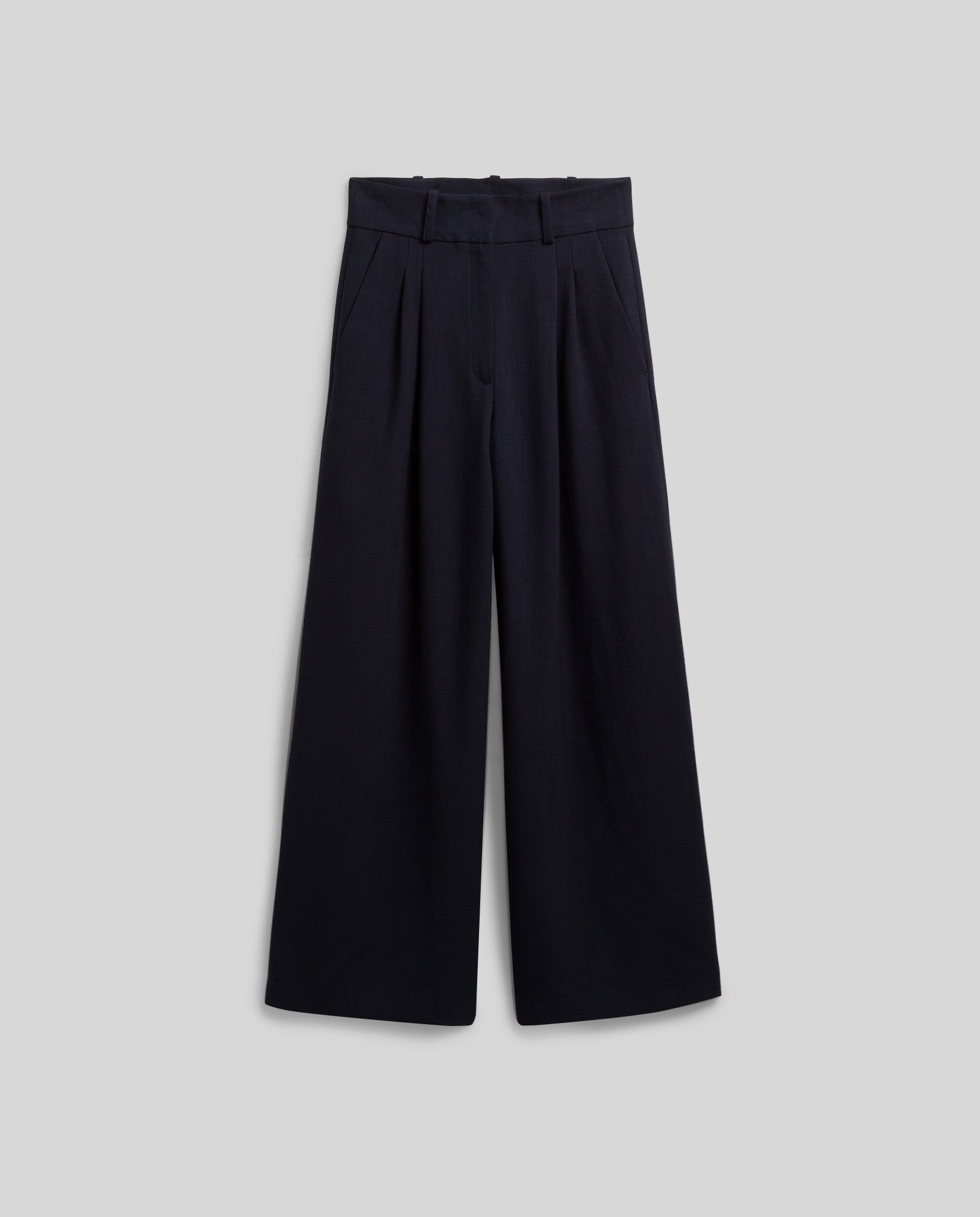 The PRESCILLIA ANN Pants by IVY OAK are high-waisted, wide-leg black trousers featuring pleats, French pockets, and belt loops, shown on a neutral background.