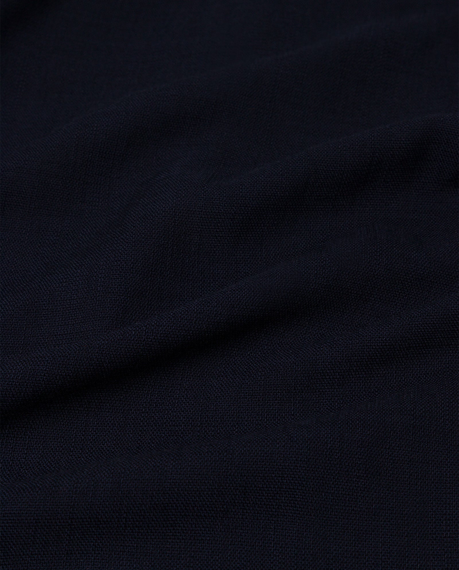 Close-up of dark navy blue fabric with visible texture and soft folds—ideal for crafting the chic PRESCILLIA ANN Pants by IVY OAK.