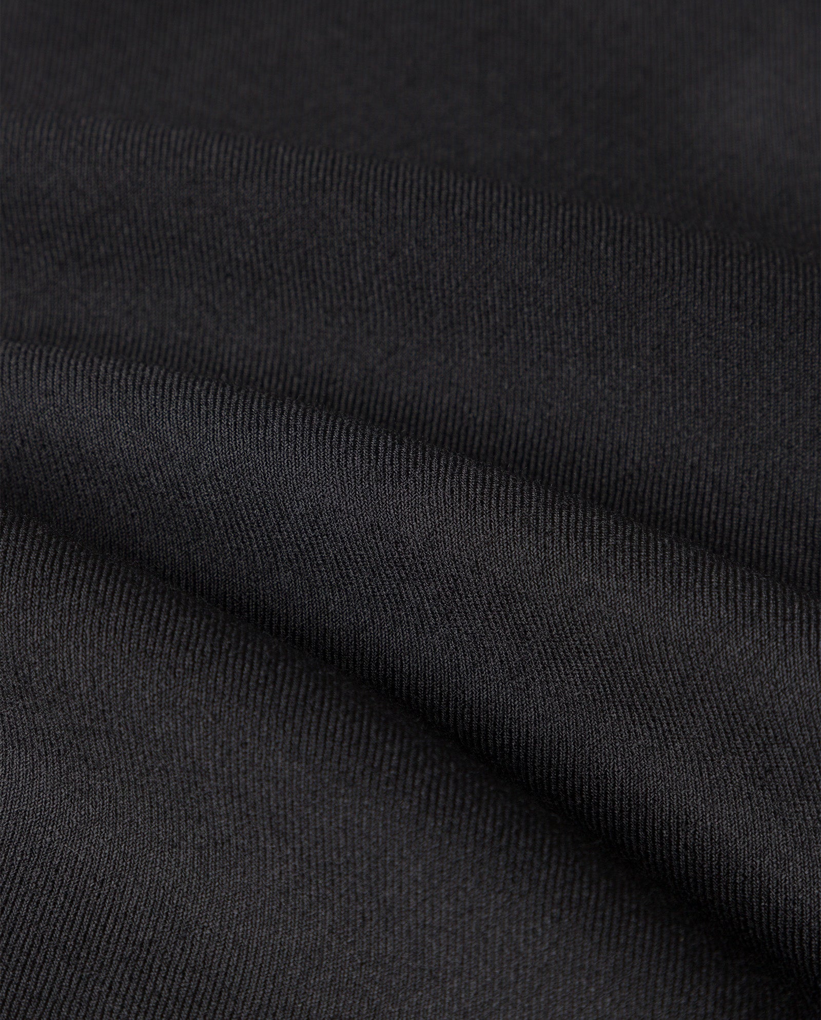 Close-up of the PERSEPHONE ANN Trouser by IVY OAK, showcasing black fabric with a fine texture and soft folds that suggest a relaxed cut and subtle pleats.