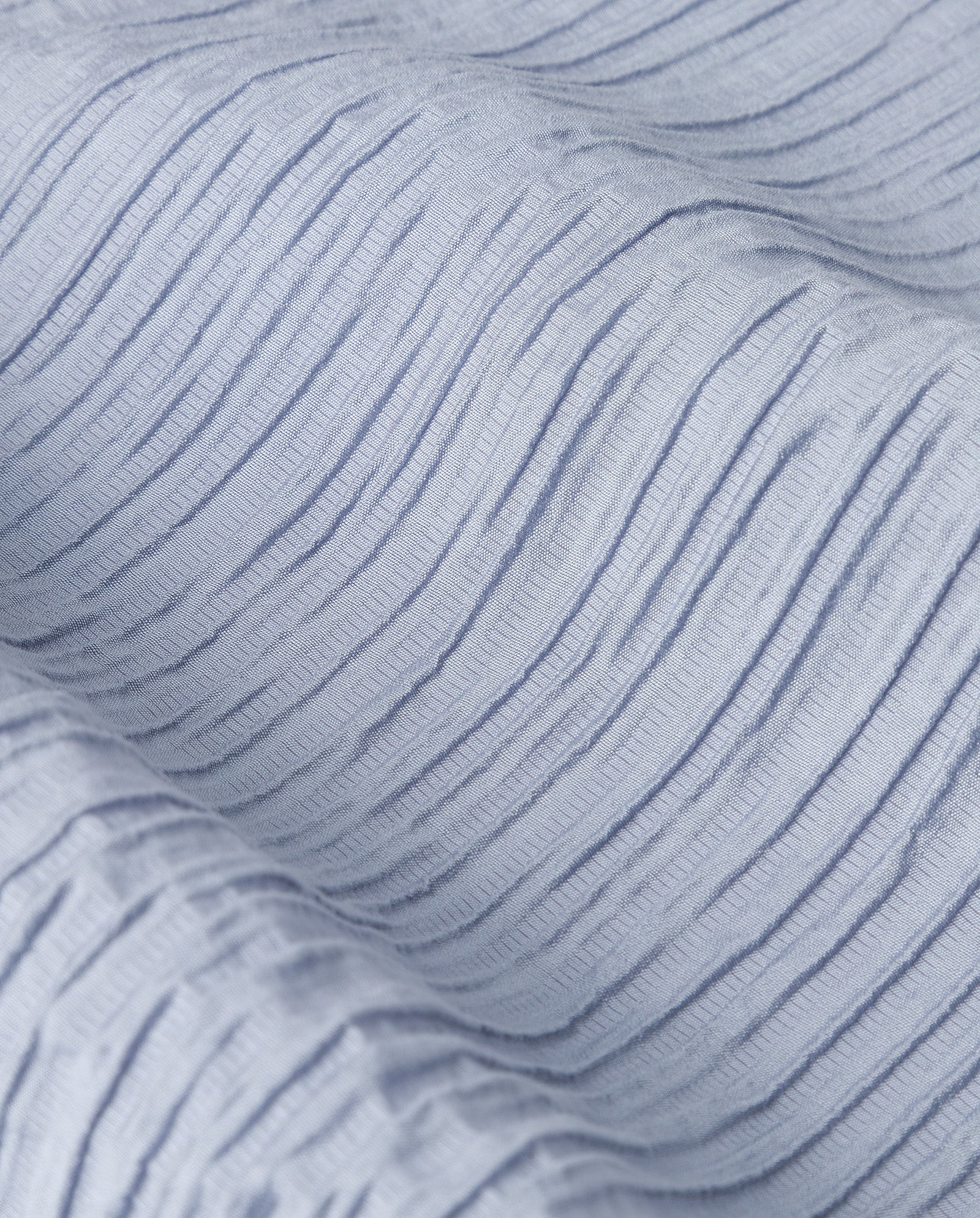 Close-up of light blue viscose fabric with textured, wavy raised lines, featured in the PORTIA Trouser by IVY OAK—ideal for pleated styles.