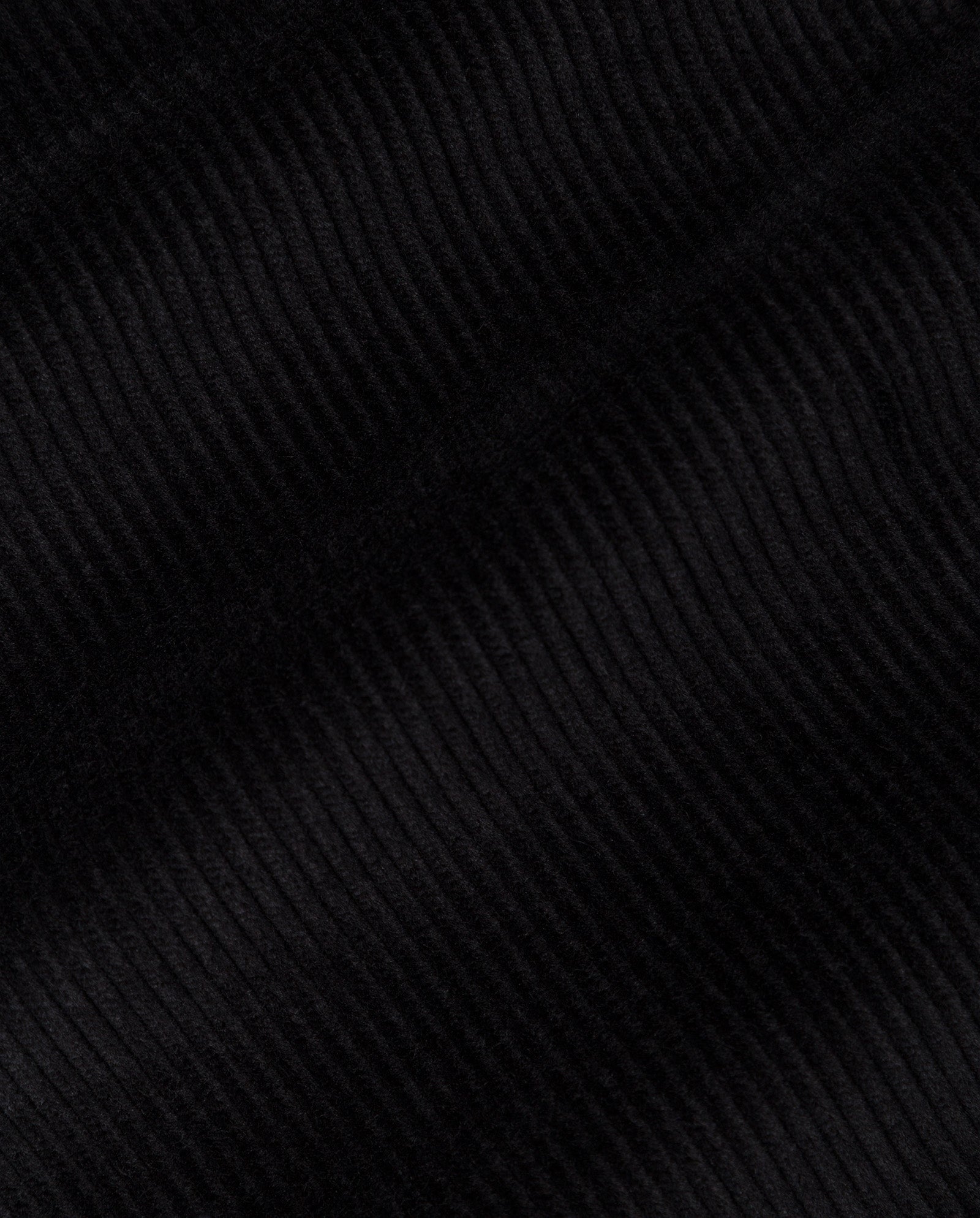 Close-up of black ribbed corduroy fabric from IVY OAKs PERNILLE ANN Trousers, highlighting its textured parallel lines and soft surface characteristic of high waist, wide leg styles.