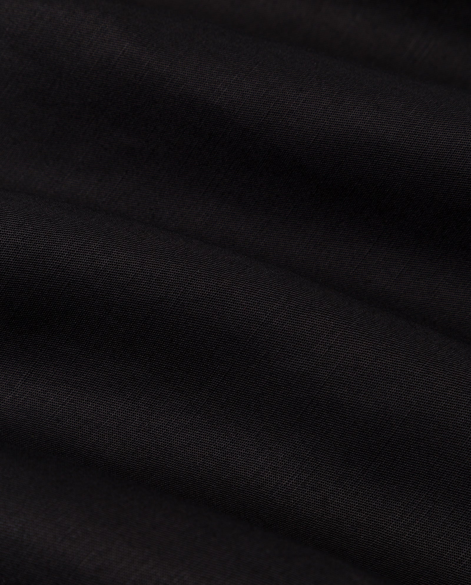Close-up of smooth, dark black fabric with soft folds and a subtle texture, ideal for IVY OAKs PIPER Trousers.