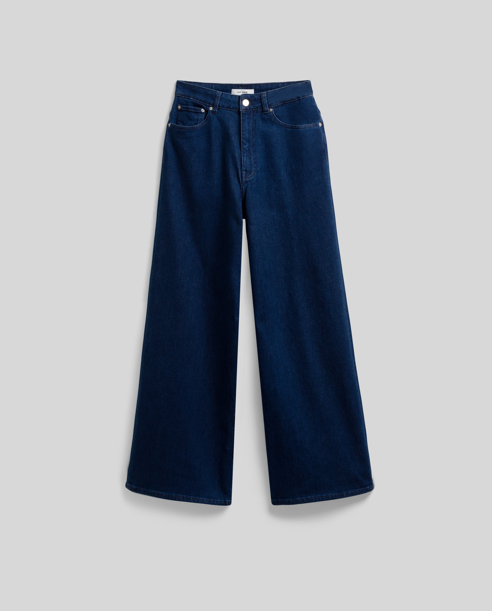 The PRIJANKA Jeans by IVY OAK are high-waisted, loose wide-leg denim in rich indigo with front pockets and a button closure, shown on a gray background.