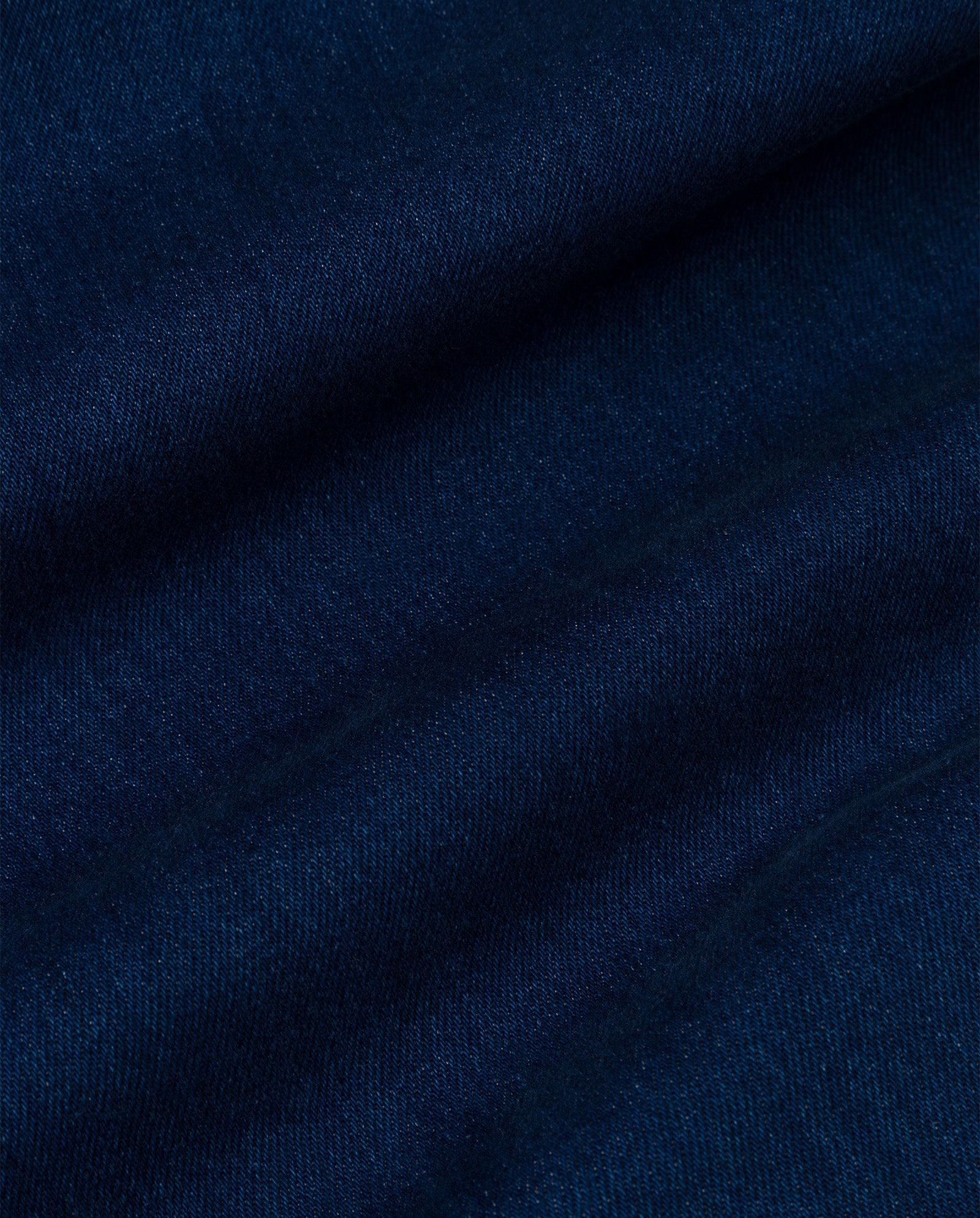 Close-up of PRIJANKA Jeans by IVY OAK, featuring rich indigo dark blue denim with visible texture and a distinctive diagonal weave pattern.