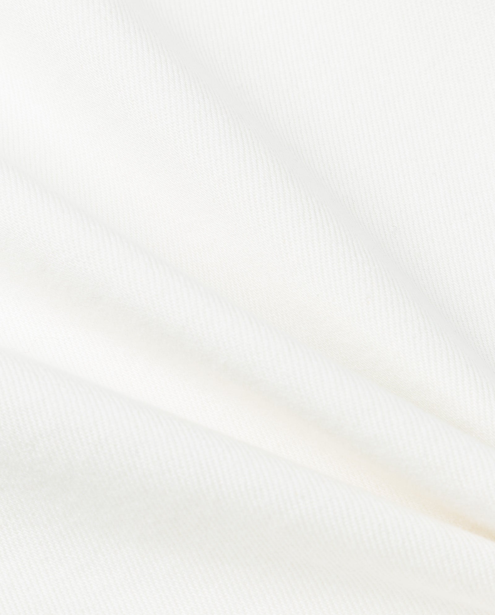 Close-up of white PHILA Pants by IVY OAK, showing diagonal folds and a subtle texture that recalls classic denim found in deconstructed trousers.