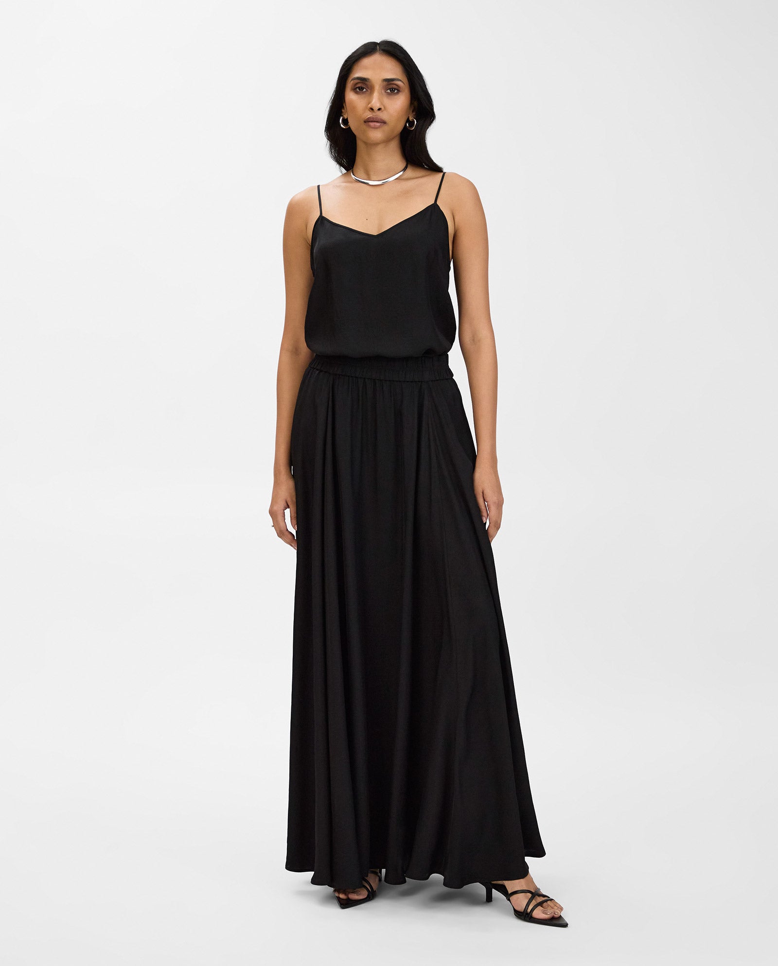 Woman wearing the IVY OAK SYLVIA MAY Skirt, paired with black sandals, standing against a plain white background.