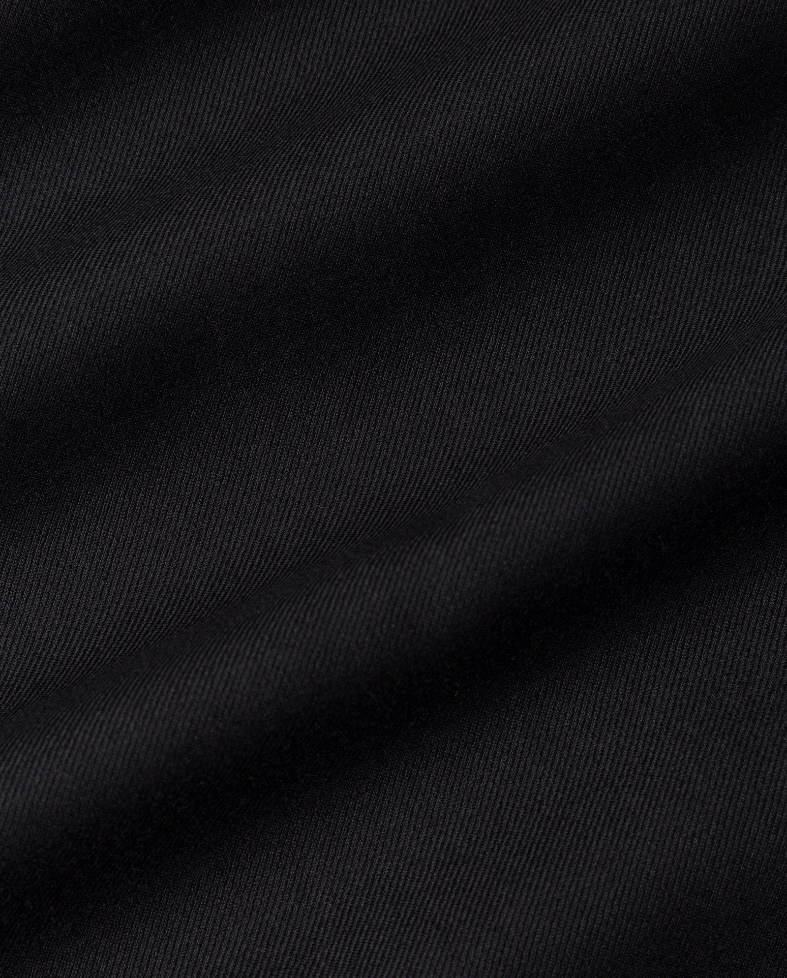 Close-up of black fabric with diagonal ribbed texture and subtle folds, from the IVY OAK SUSANNA Skirt—ideal for a pleated look.