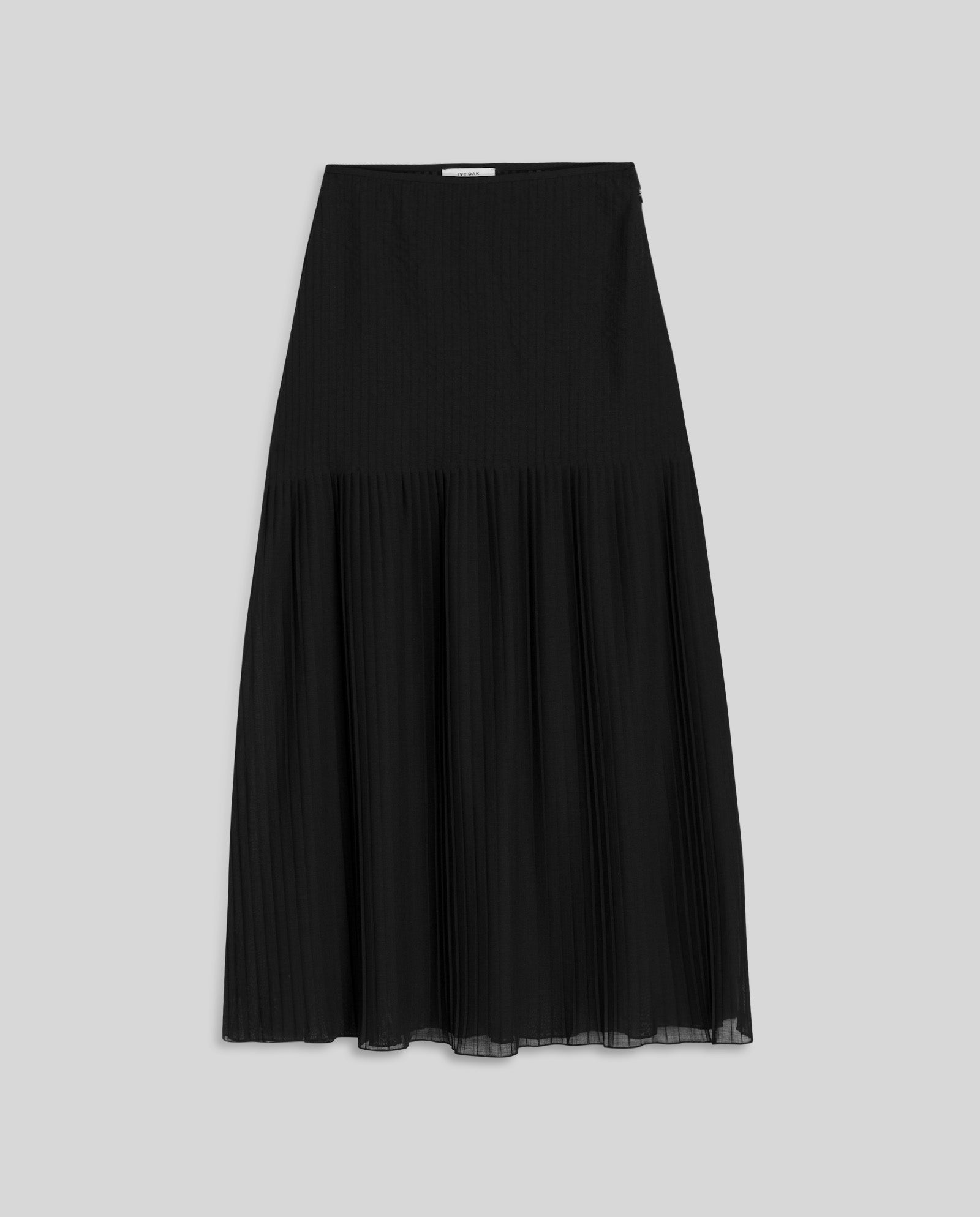 The IVY OAK SALENA Skirt is a long black luxury plissé skirt with a smooth waistband, shown on a light gray background.