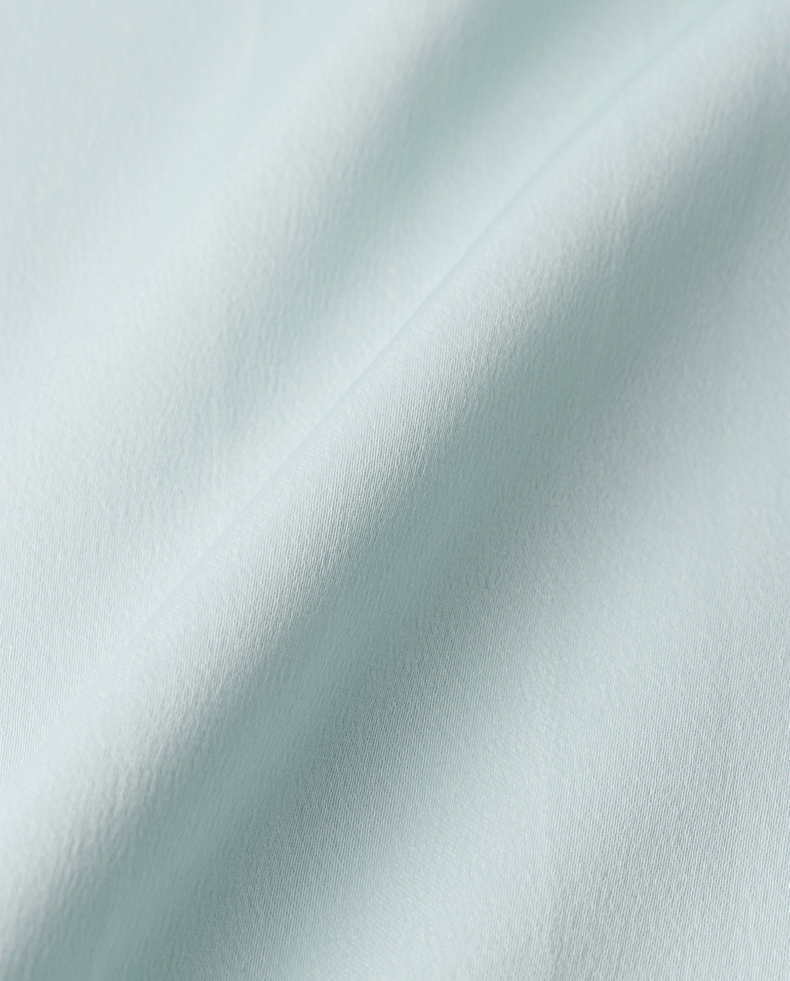 Close-up of shiny light blue satin with a smooth texture and soft folds, perfect for the elegant ankle-length NOEL Dress by IVY OAK.