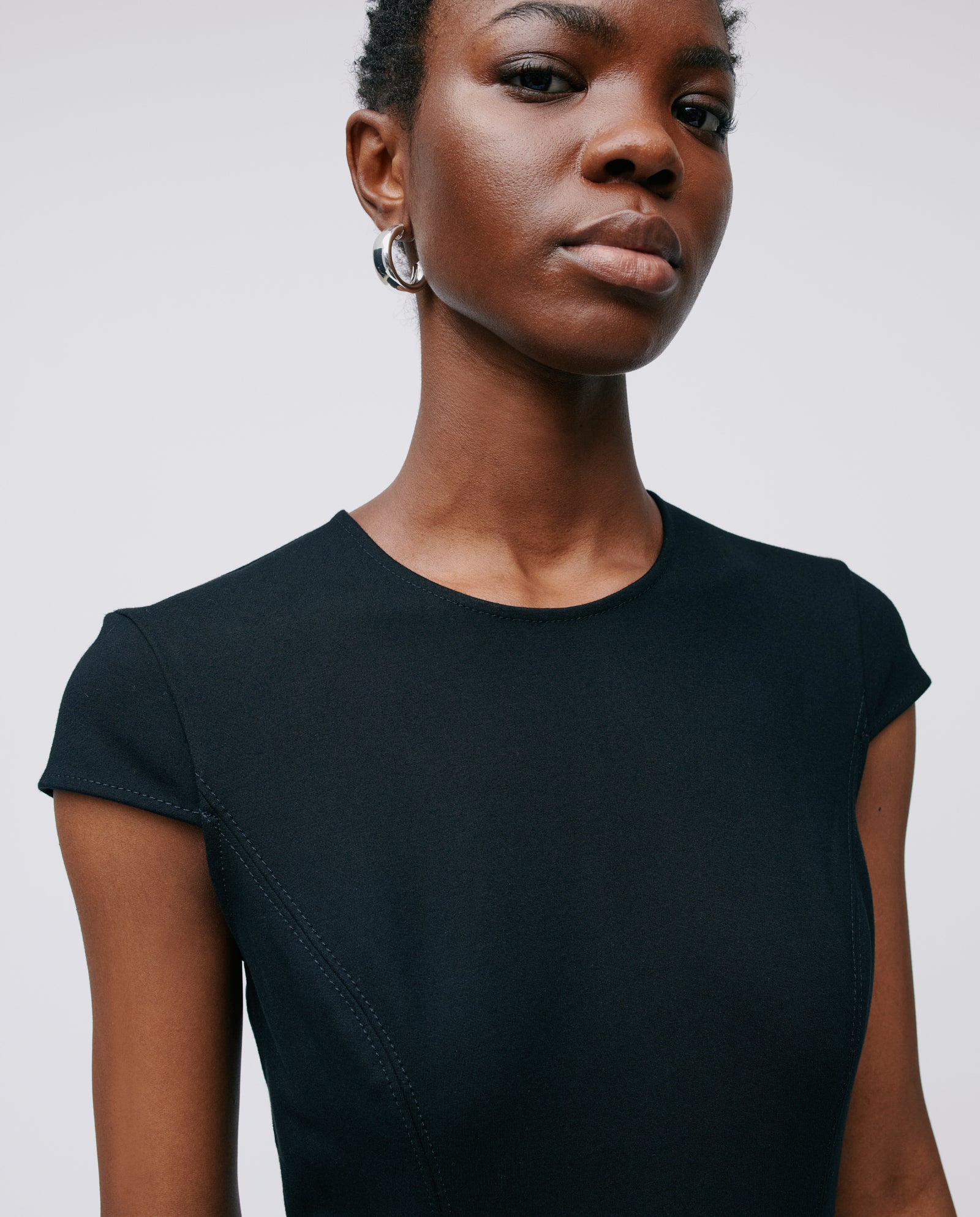 A woman in an IVY OAK DAFNI dress gazes confidently at the camera against a plain background, making it perfect for special occasions.