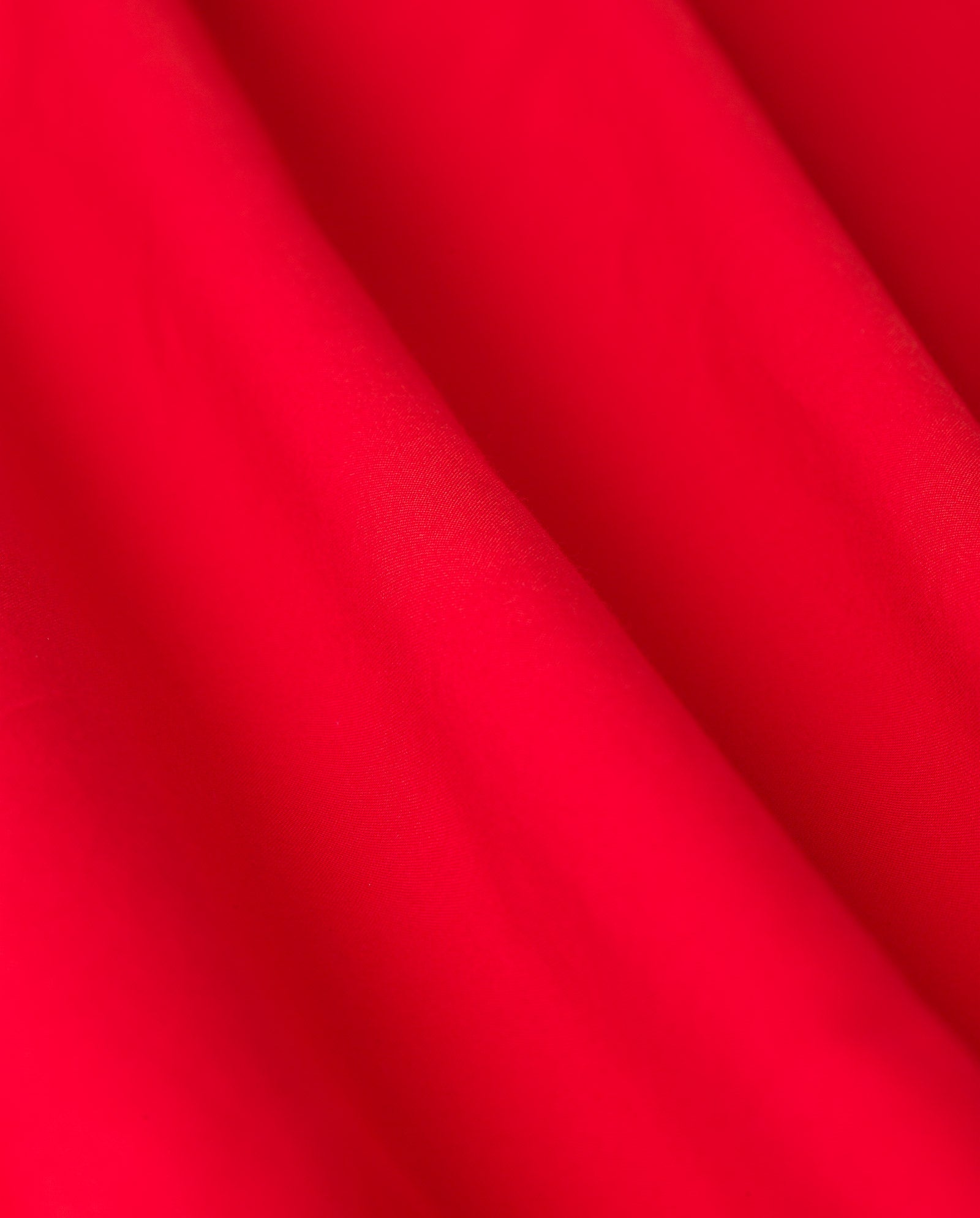 Close-up of vibrant red fabric from the MARYTHA Dress by IVY OAK, highlighting its soft folds and smooth texture.