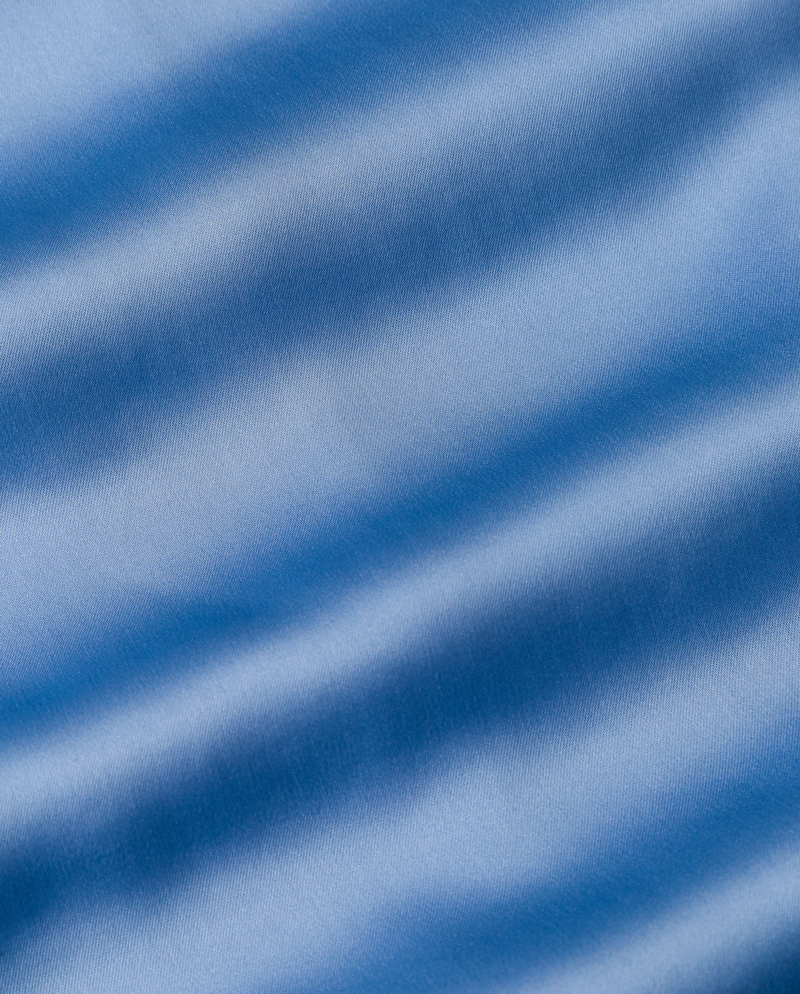 Close-up of light blue fabric with soft, wavy folds, suggesting the elegant drape of the DARCI ANN Dress by IVY OAK.