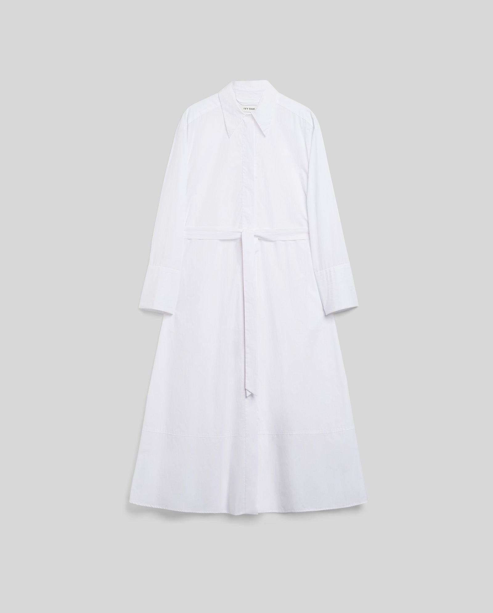 The IVY OAK DINA ROSA Dress is a long-sleeved white shirt dress with a collar, button closure, adjustable cuffs, and matching belt, shown on a plain background.